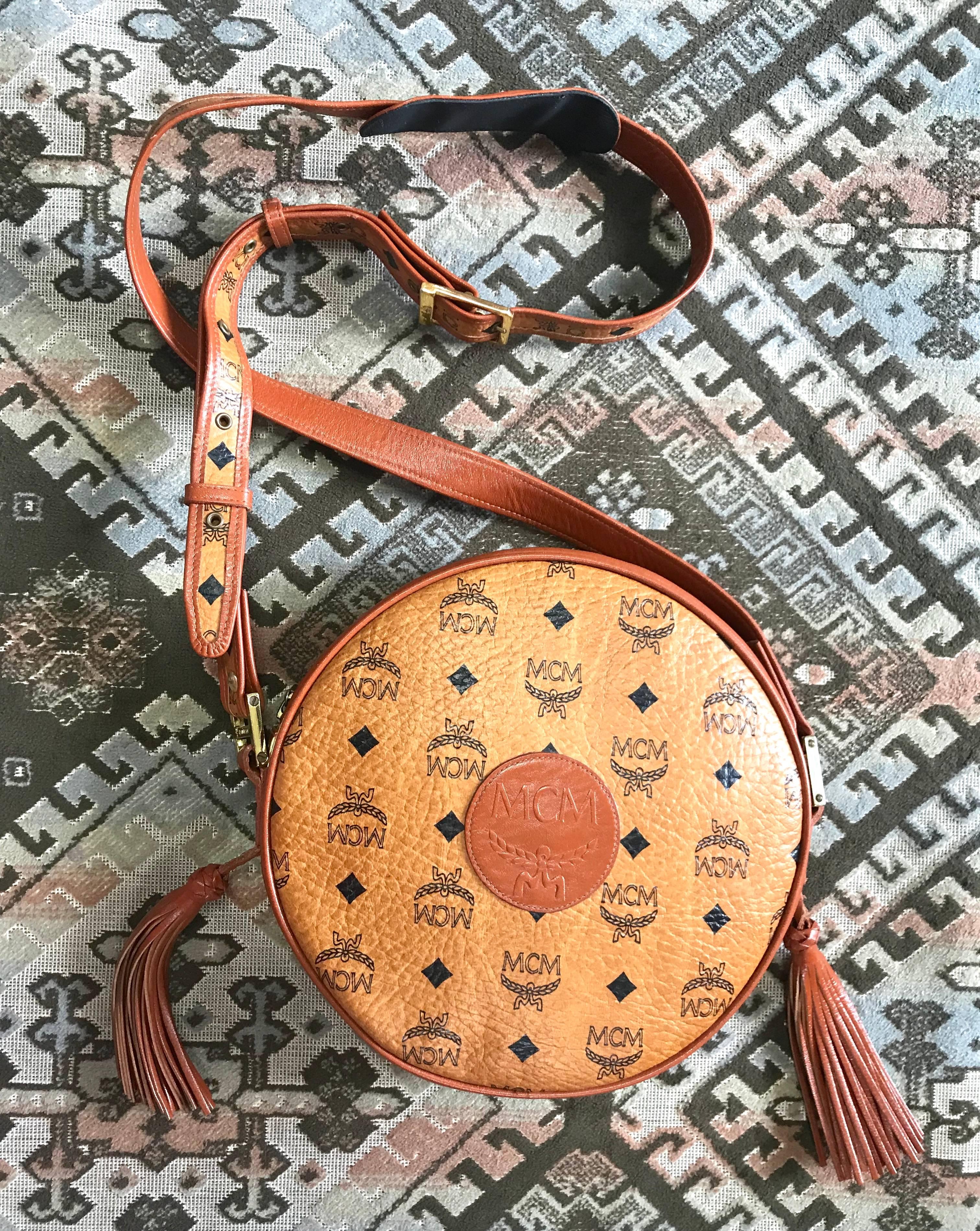1990s. Vintage MCM brown monogram round Suzy Wong shoulder bag with brown leather trimmings. Designed by Michael Cromer. Masterpiece. Unisex.

MCM has been back in the fashion trend again!!
Now it's considered to be one of the must-have designer in