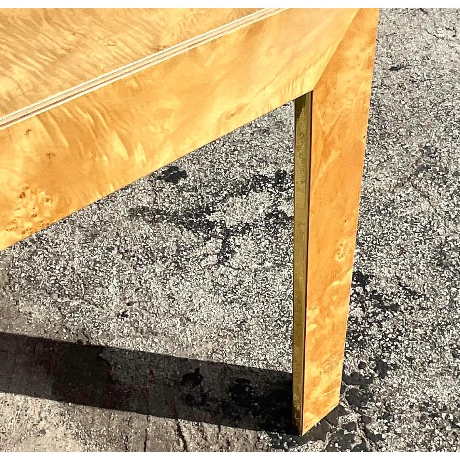 A fantastic vintage Boho MCM dining Table. Done in the manner of Milo Baughman. Gorgeous pale Burl wood in a chic Parsons shape. Strips of brass add a little flash of glamour to the leg interiors. Two leaves included. Acquired from a Palm Beach