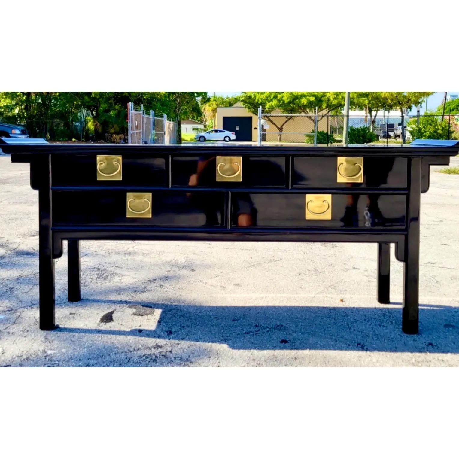 Incredible vintage century credenza. Chic black lacquer with heavy brass ming hardware. Pagoda wing details. Acquired from a Palm Beach estate.