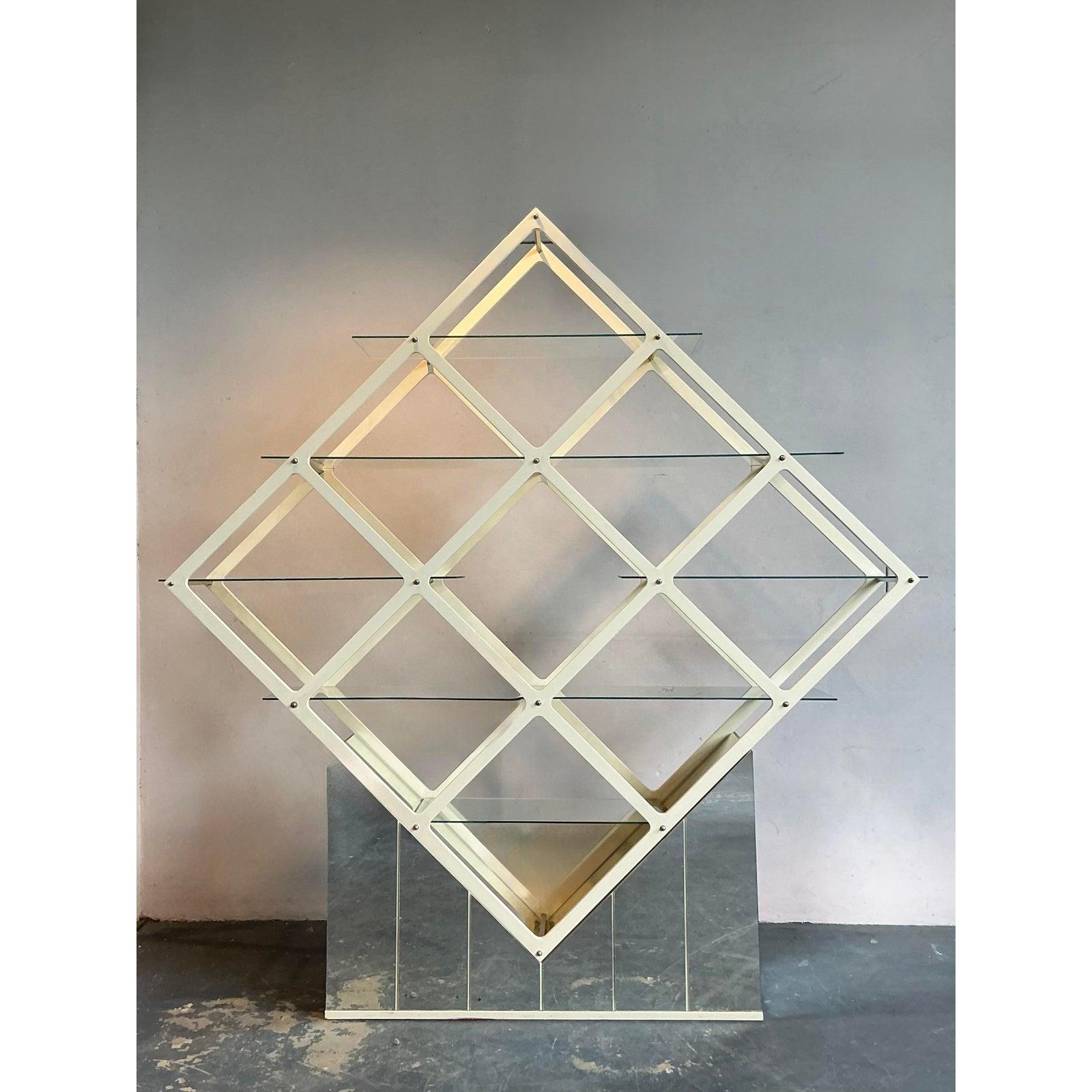 Eleva i tuoi interni con questa straordinaria Etagere Vintage Mid-Century Modern Diamond, un vero e proprio pezzo forte che incarna la raffinatezza geometrica della sua epoca. Realizzata con una struttura pulita in lacca bianca che forma un