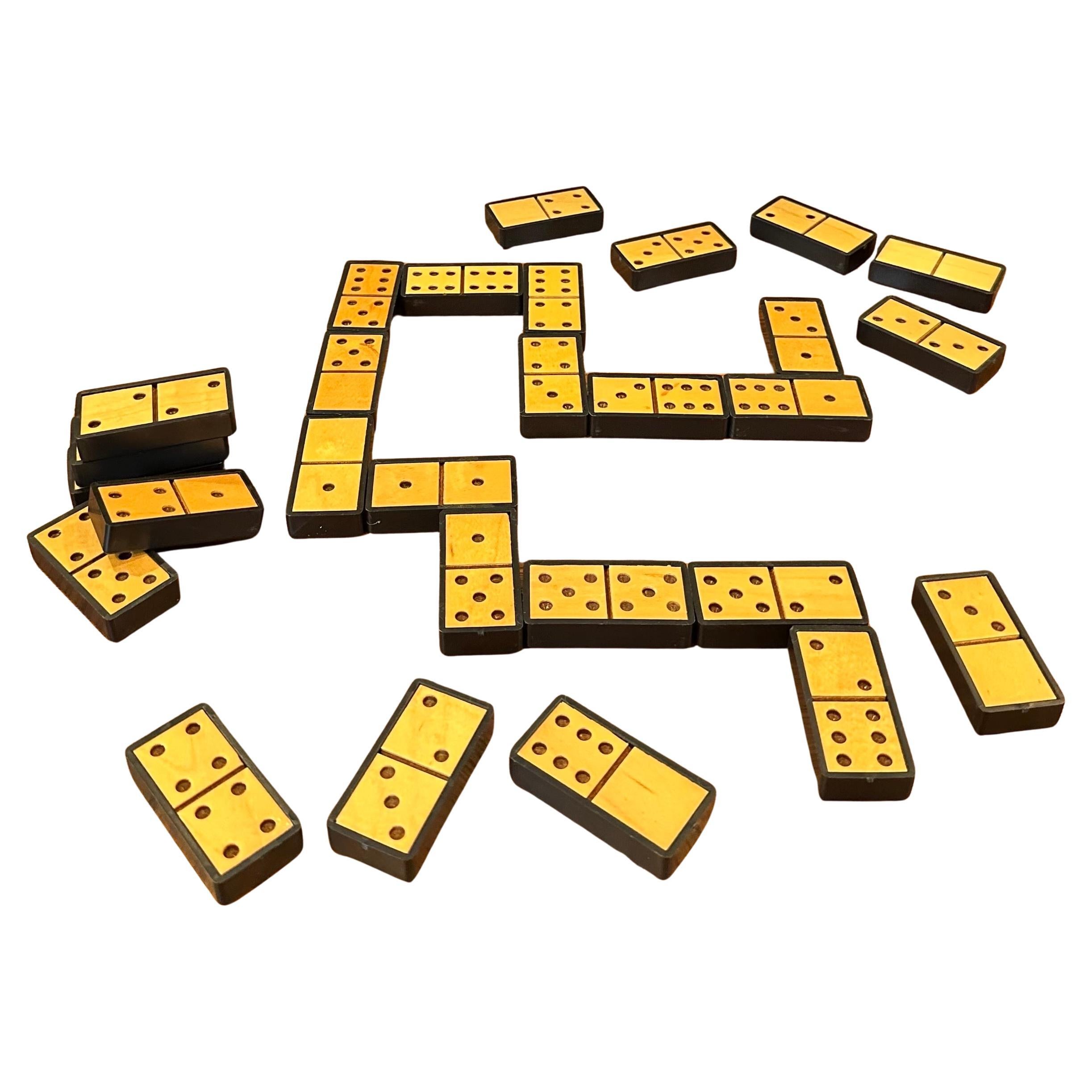 A very cool MCM domino set in lidded wooden box, circa 1970's. The set is in very good condition, includes 28 dominoes and measures 3.5