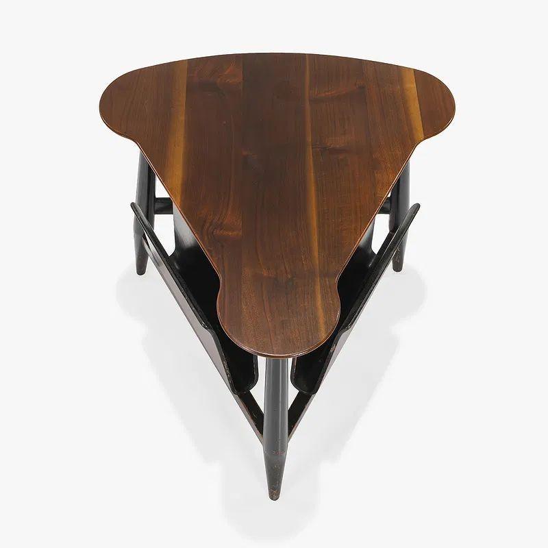 Vintage MCM Edward Wormley for Dunbar magazine table. Circa 1960. Created in 1953, this table features a triangular walnut top with rounded corners, paired with a dark-stained walnut frame and two bentwood mahogany magazine racks beneath, all
