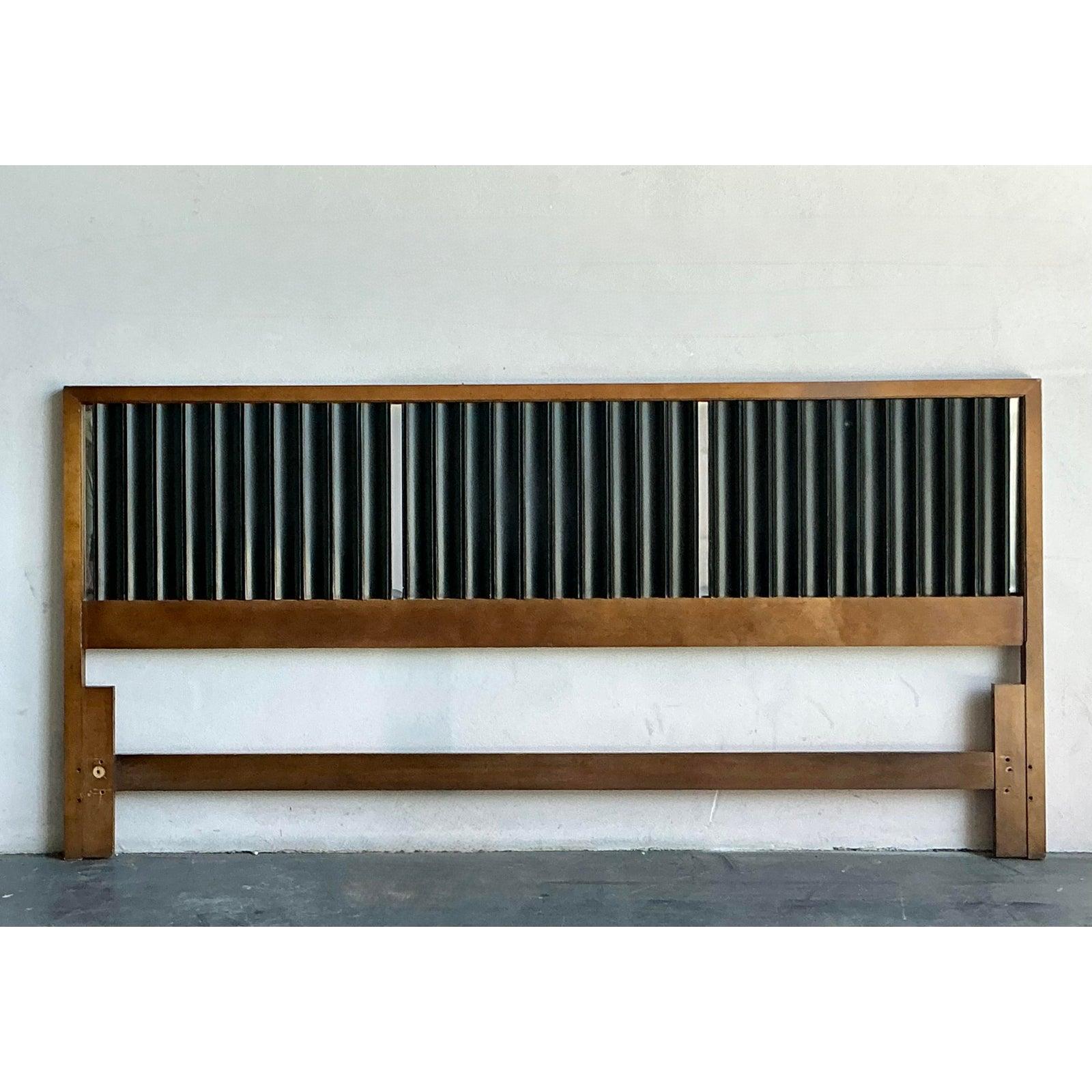 Questa imponente testiera King-size cattura la raffinatezza architettonica e i contrasti drammatici emblematici del più importante design del Mid-Century Modern. L'ampia struttura è caratterizzata da una calda e ricca cornice in legno di noce che