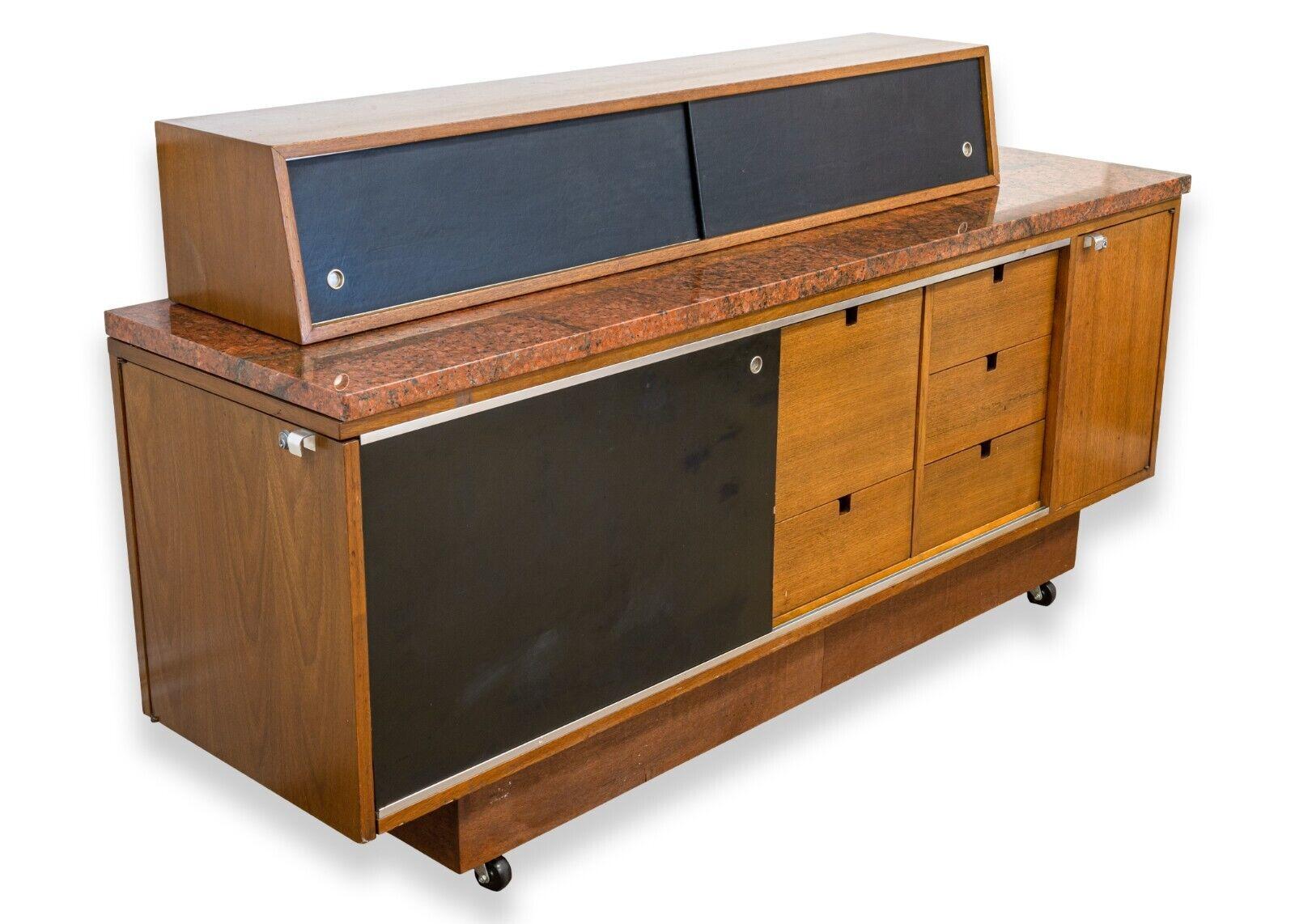 A mid century modern George Nelson for Herman Miller custom designed sideboard credenza. A stunning piece of iconic furniture from George Nelson for Herman Miller. This sideboard credenza features a custom red granite top, rolling caster legs, a