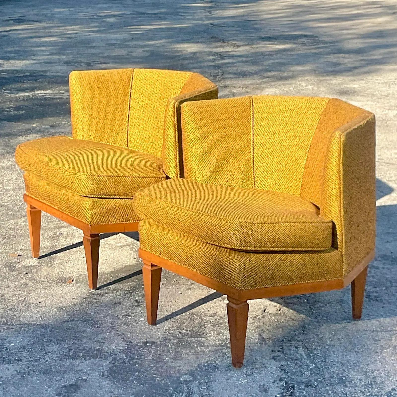 A chic pair of vintage MCM lounge chairs. A hexagon shape in a brilliant golden color. Rest on a wooden Millwork base. Acquired from a Palm Beach estate.