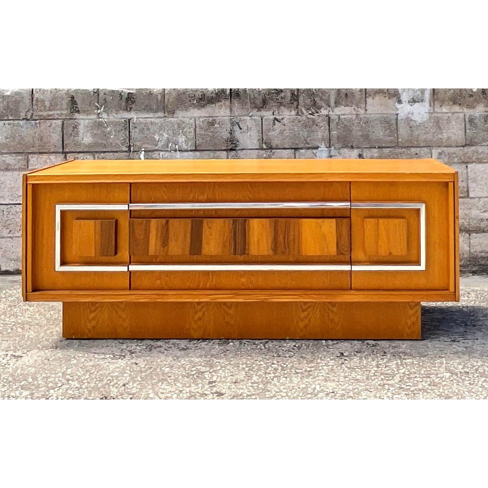 Fantastic vintage MCM credenza. Gorgeous wood grain inset panel with a chrome band surround. Lots of great storage below. Acquired from a Palm Beach estate.
