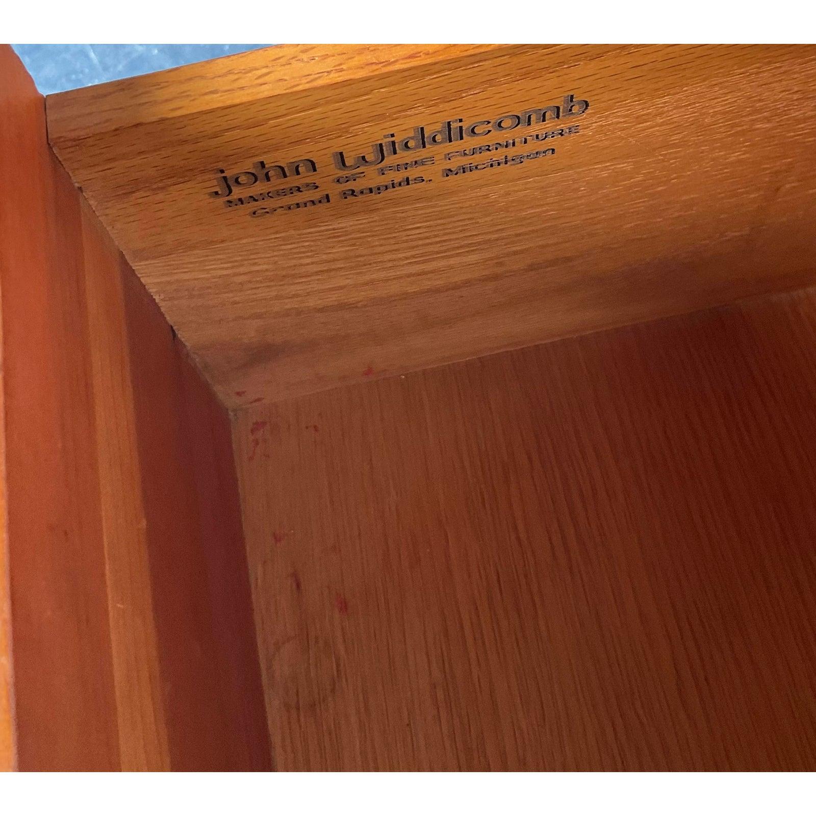 Ti presentiamo un superbo comò d'epoca Mid-Century Modern a nove cassetti dello stimato John Widdicomb, Makers of Fine Furniture. Questo pezzo eccezionale, probabilmente risalente agli anni '60, esemplifica il design sofisticato dell'epoca con le