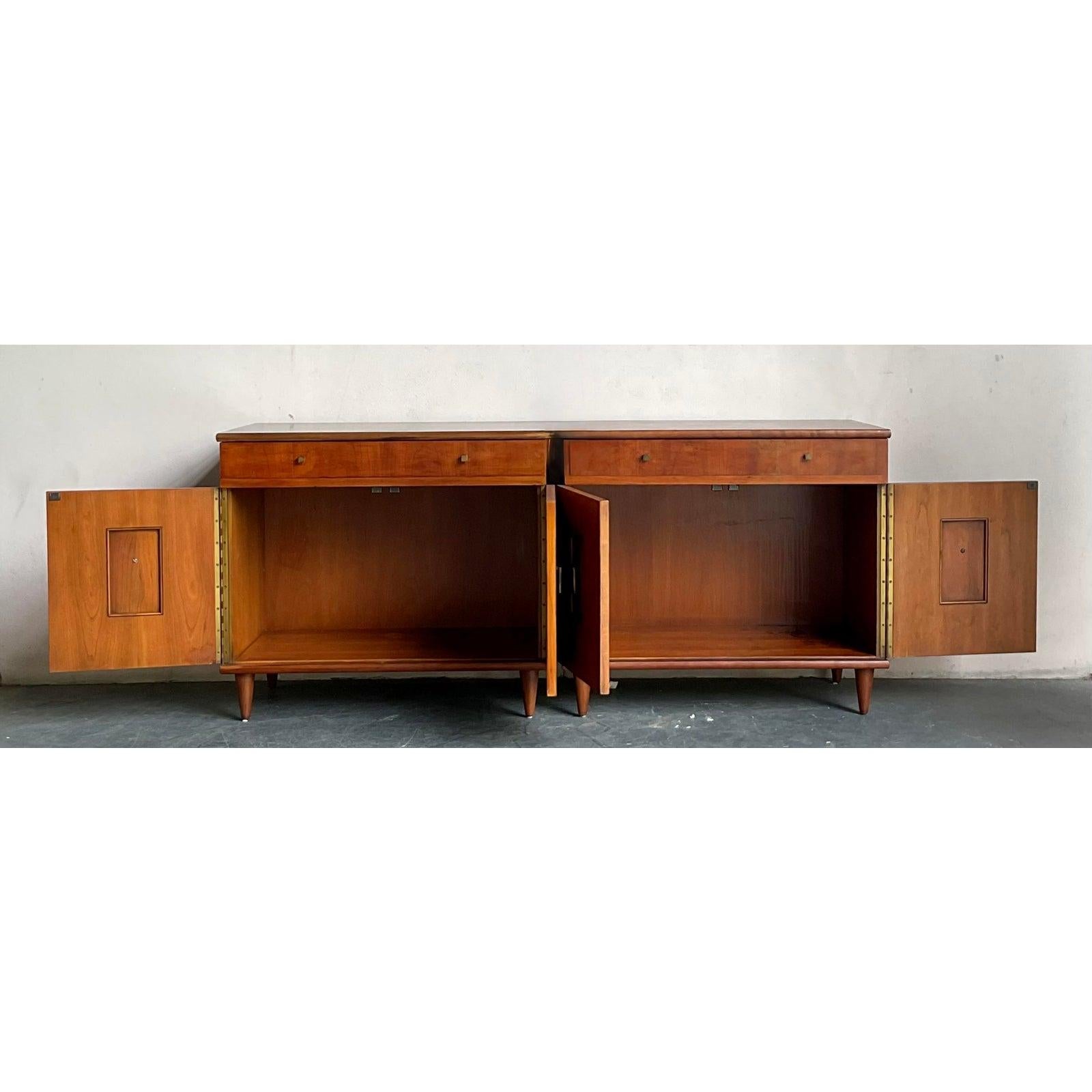 Scopri questa eccezionale coppia di comodini d'epoca a due ante in stile Mid-Century Modern del rinomato John Widdicomb, Makers of Fine Furniture. Questi squisiti pezzi, probabilmente risalenti agli anni '60, mostrano il design sofisticato