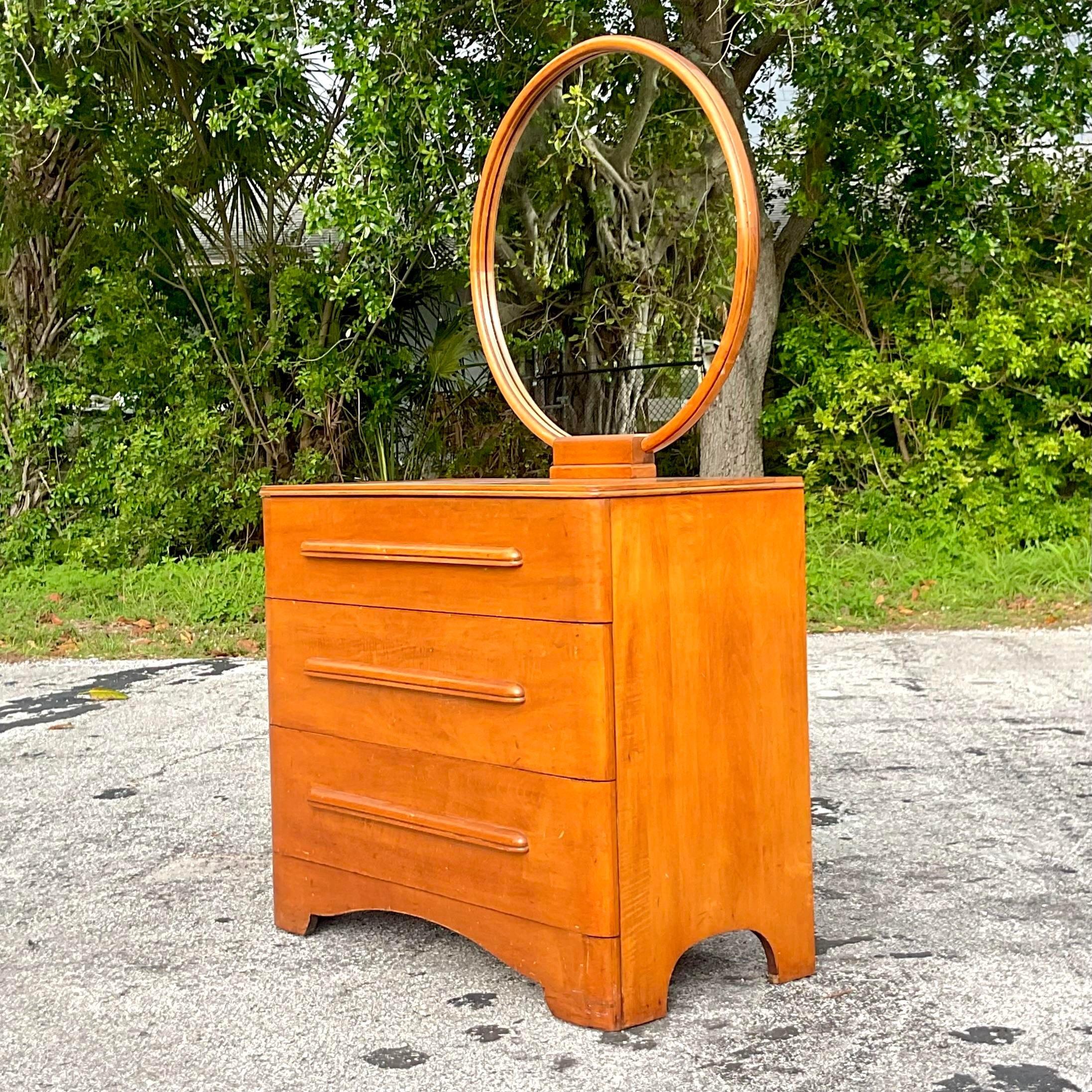 Experience mid-century modern charm with this vintage MCM maple dresser featuring a round mirror, a timeless embodiment of American craftsmanship and design ingenuity. Crafted with exquisite maple wood, its clean lines and sleek silhouette evoke a