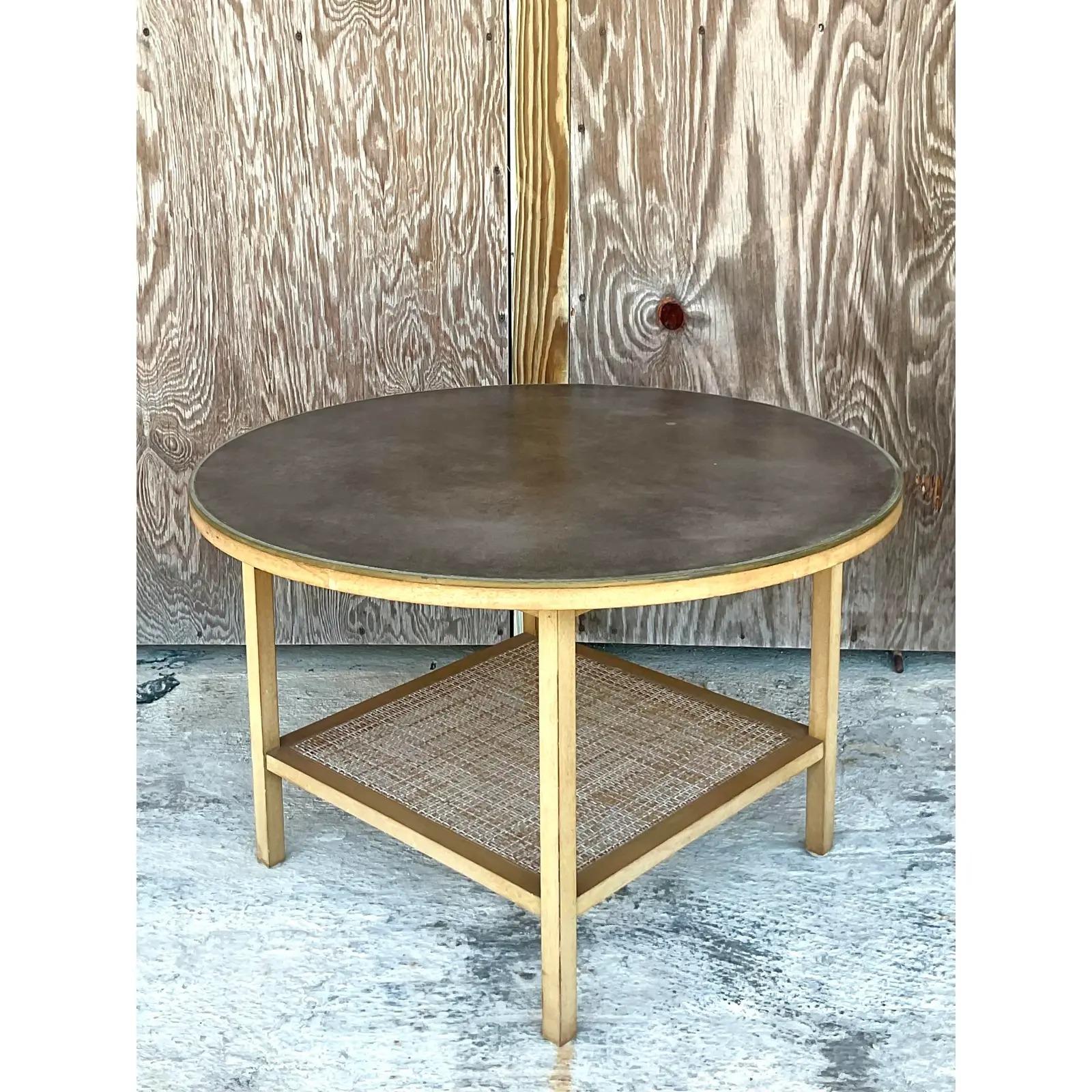 Fantastic vintage MCM side table. A chic round shape with an inset leather top and woven rattan second shelf. Made by the iconic Paul McCobb and designed for Calvin. Part of the coveted Irwin collection. Perfect as a side table or a coffee table.
