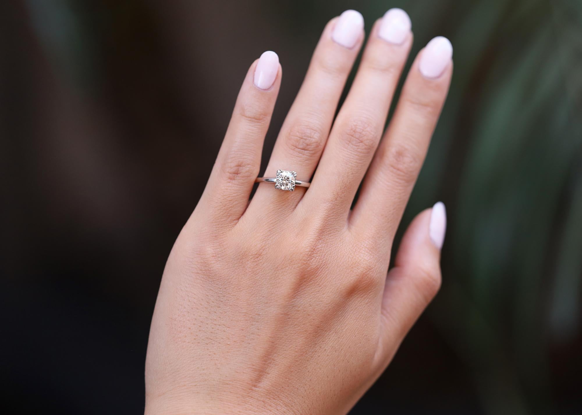 This classic mid century solitaire engagement ring is an excellent choice for those seeking value and eco-friendly sustainability. Showcasing a 0.80 carat round brilliant diamond with VS1 clarity, sparkling with modern brilliance and fire within.