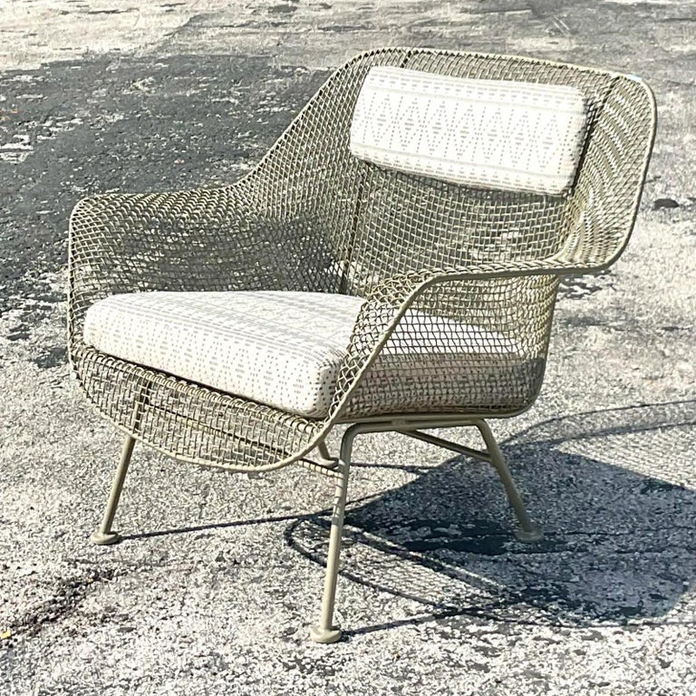 A fabulous vintage MCM wrought iron chair. Made by the iconic Russell Woodard. Fully restored by Huniford Design Group with new pair and custom upholstery. Acquired from a Palm Beach estate.