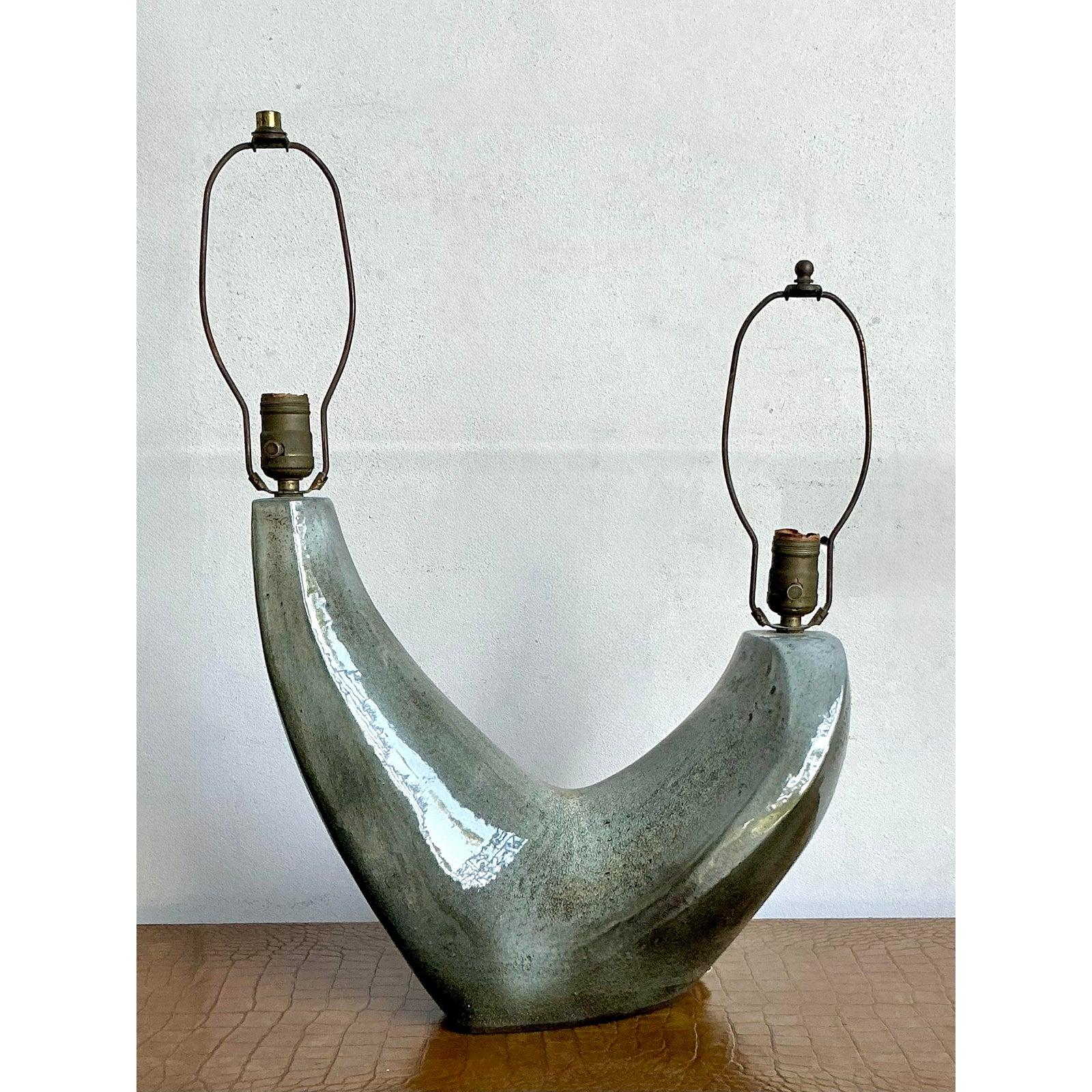 Cette étonnante lampe de table vintage est un exemple magistral du design de studio du milieu du siècle, avec sa silhouette sculpturale en forme de 