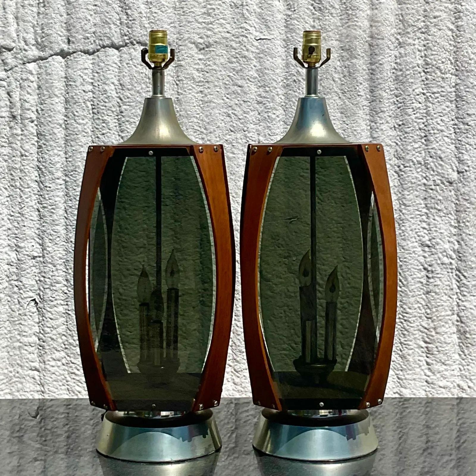 Vintage pair of MCM table lamps. Beautiful teak wood frame with smoked glass panels. Interior candle lights inside. Acquired from a Palm Beach estate.