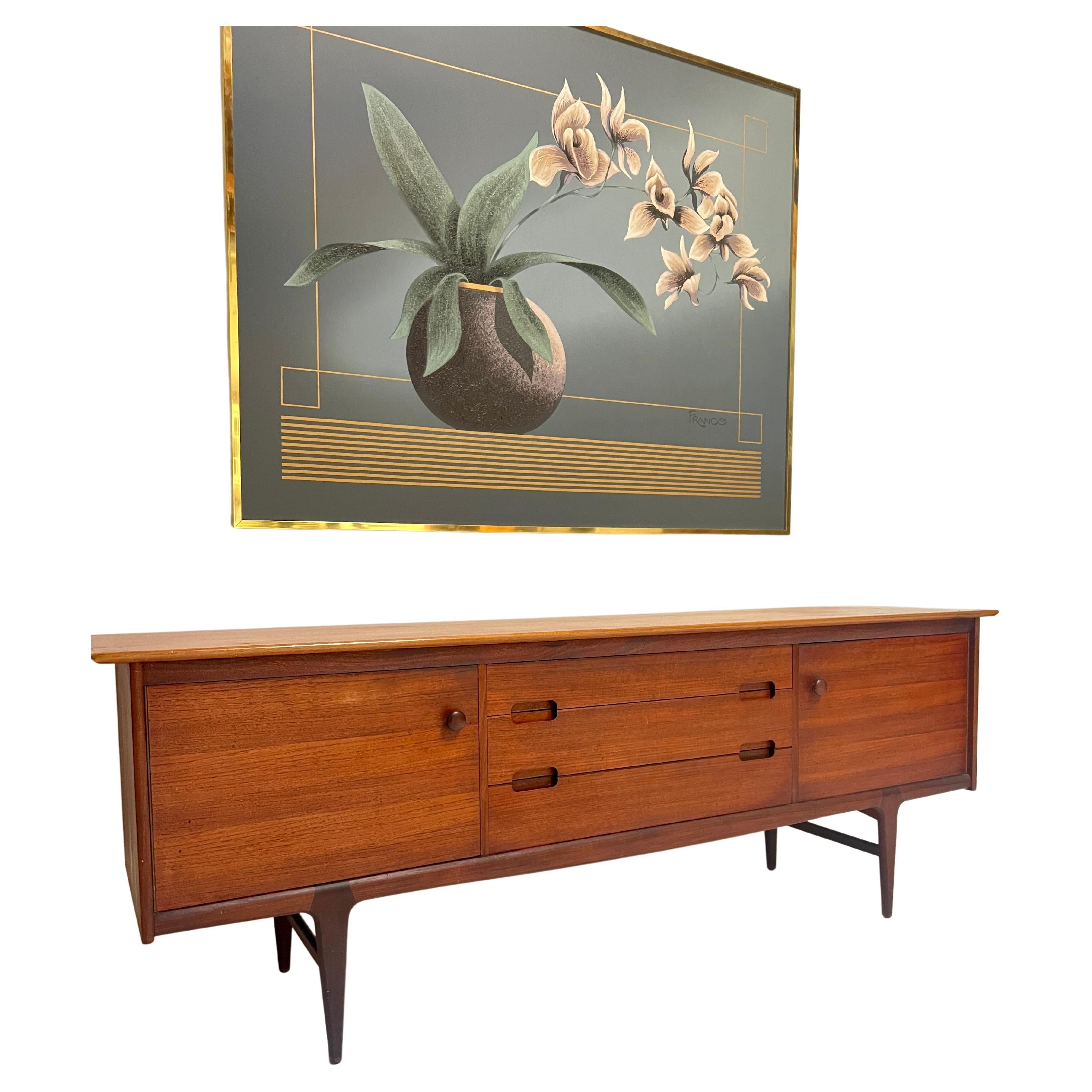 Beautiful vintage teak sideboard designed by John Herbert, part of the Fonseca line by A. Younger Furniture circa 1960's. It features solid teak and teak veneer construction, subtly curved edges, inset drawer pulls, turned teak door handles and