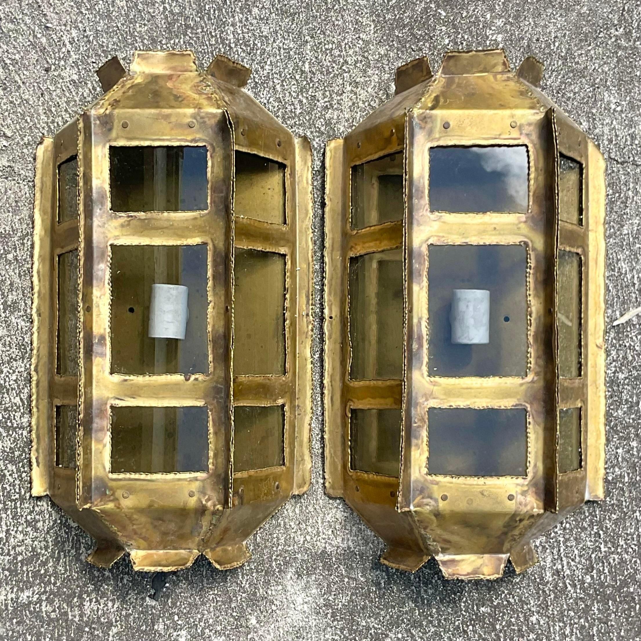 A fantastic pair of vintage MCM wall sconces. Made by the iconic Tom Greene for Feldman. Chic torch cut design with smoked glass panels. Acquired from a Palm Beach estate.
