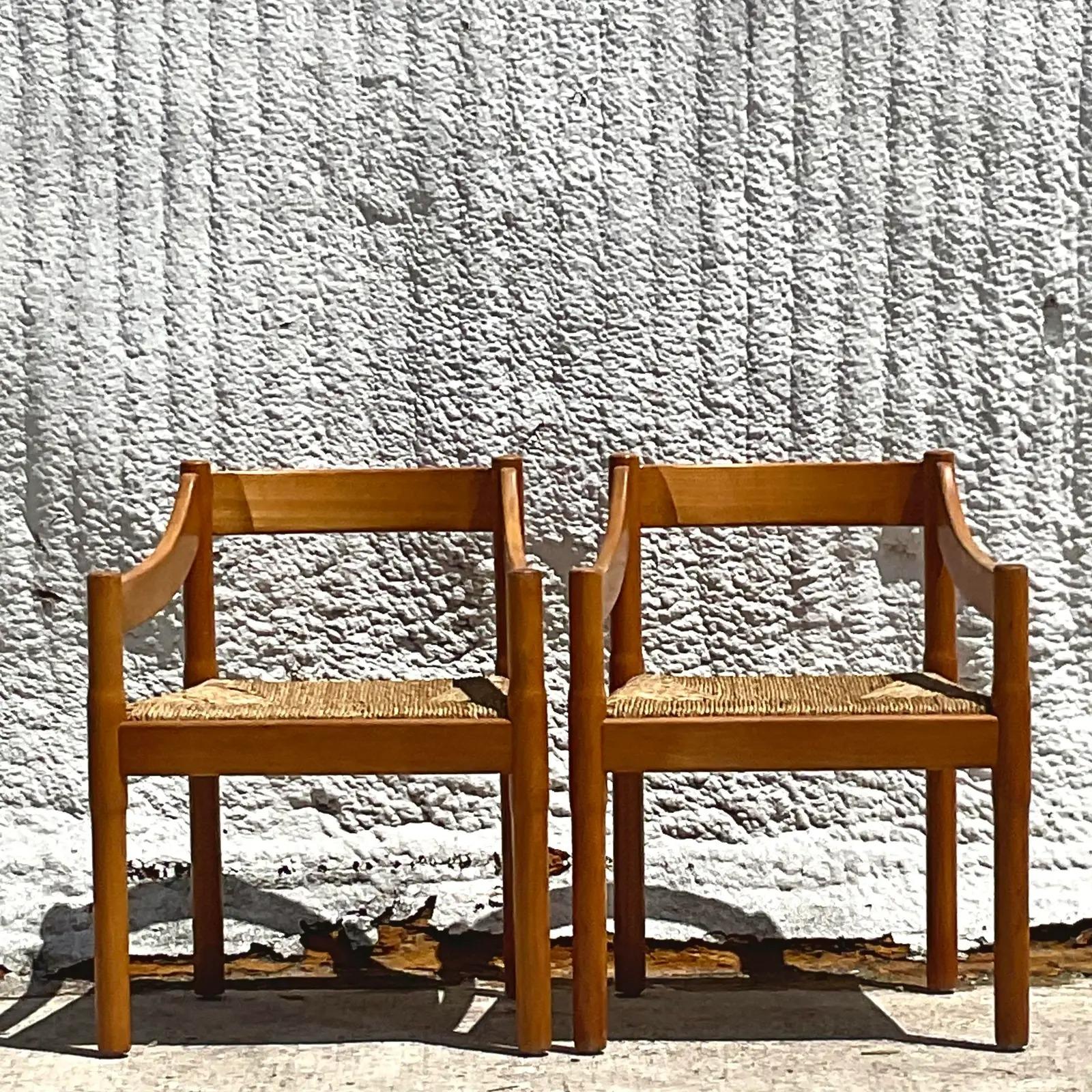 A fantastic pair of vintage MCM arm chairs. Made in Yugoslavia and marked on the bottom. Beautiful slope arm design with wide rush seats. Acquired from a Palm Beach estate.