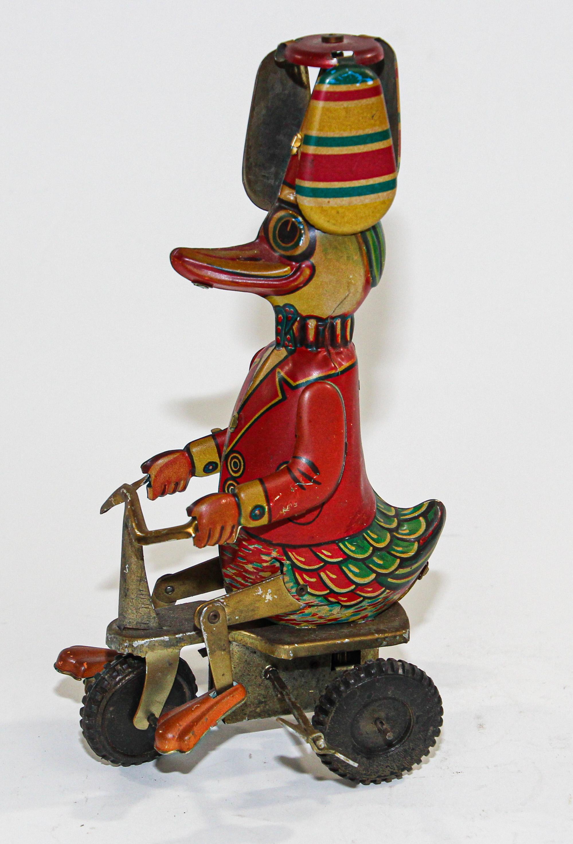 Vintage style mechanical tin metal wind-up duck on bike.
In good working order 
This vintage style wind-up toy is made of beautify printed tin. 
Use the key to wind up the colorfully dressed happy duck and watch him pedal his bike while the