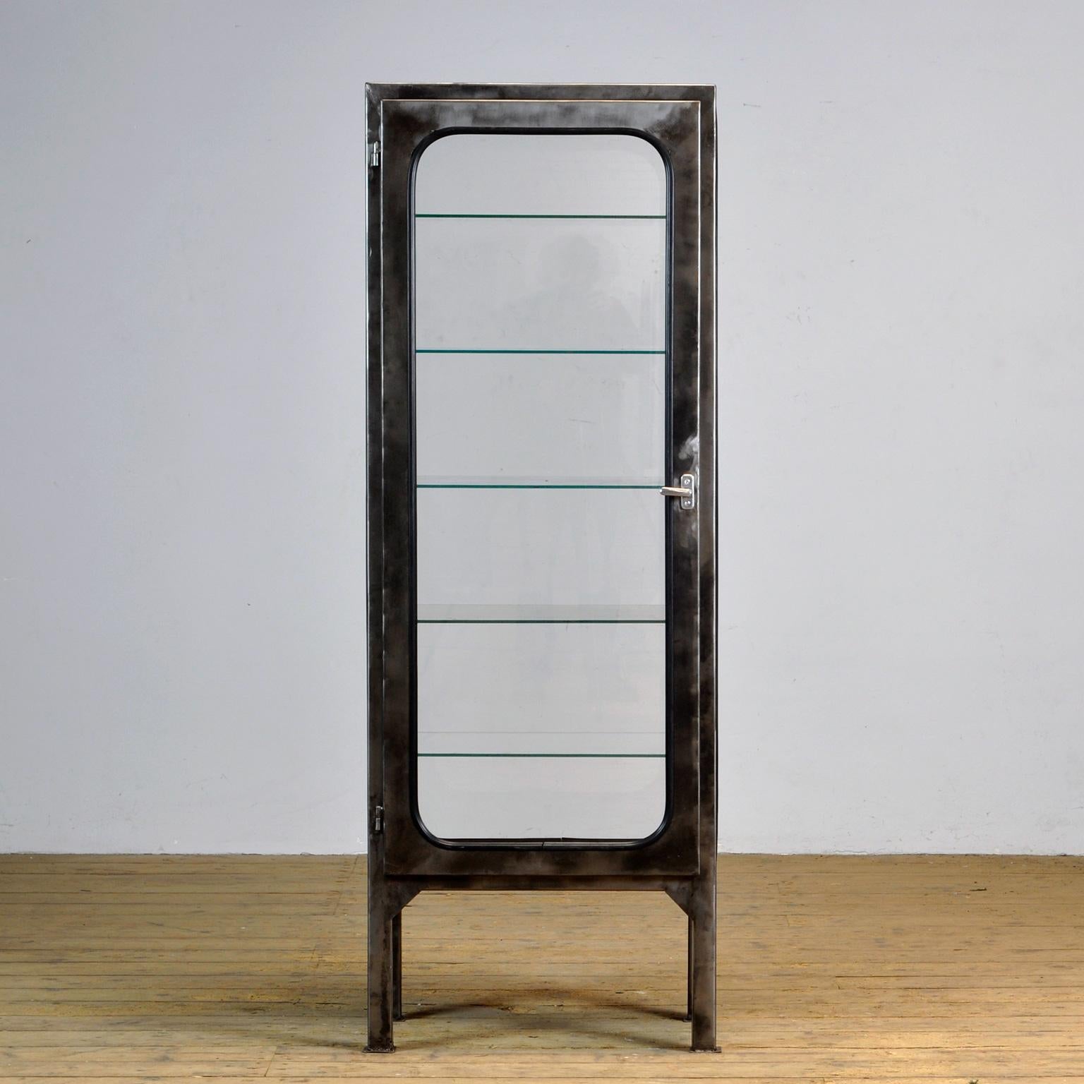 Made of steel and glass that is clamped in the steel by a rubber strip. The cabinet is from the 1970s and was produced in Hungary. The showcase has been stripped to the metal and finished with a transparent lacquer. Comes with 5 glass (adjustable)