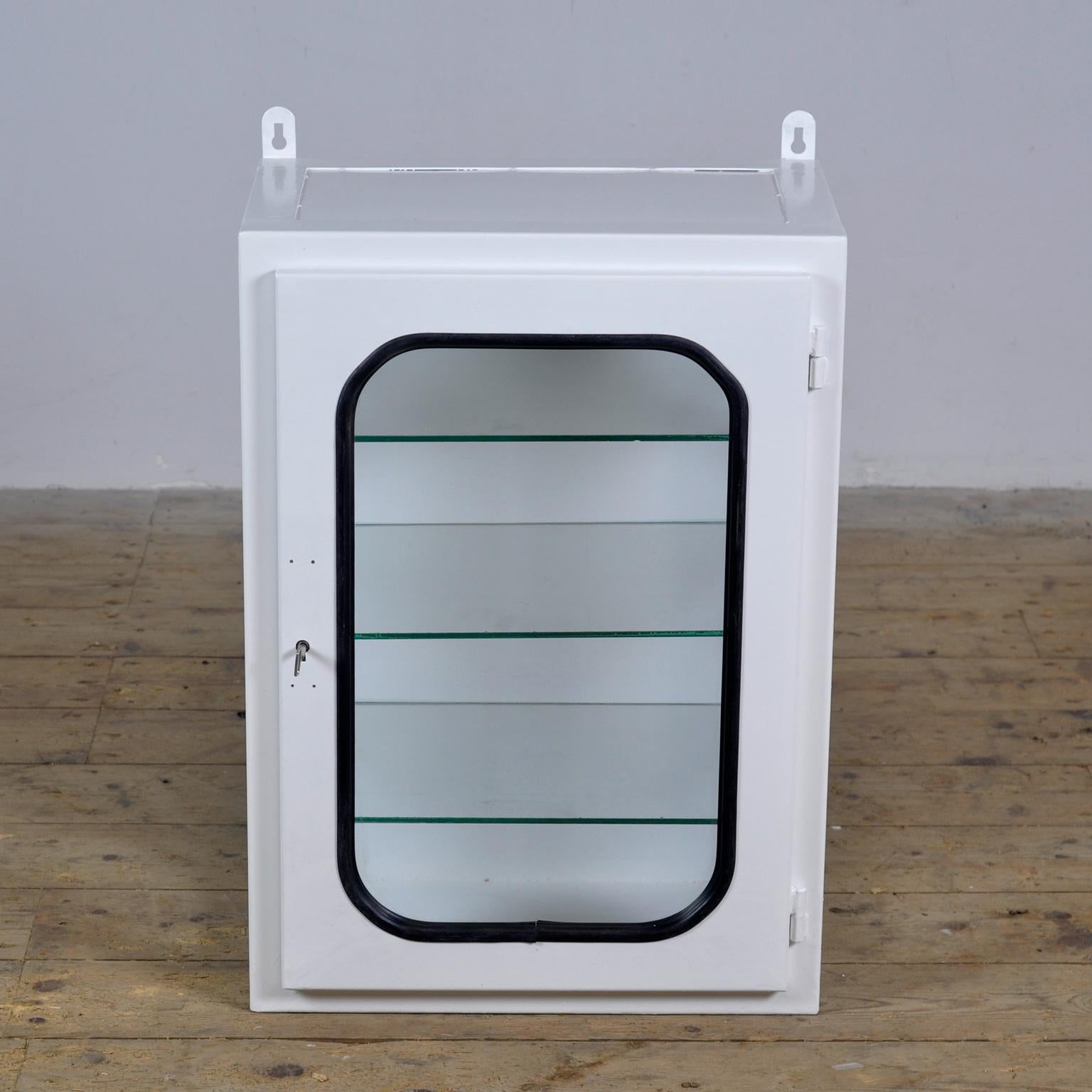 Medicine cabinet (wall unit) from a hospital. Made of iron and glass that is clamped into the steel by a rubber strip. This cabinet comes from the 70s and was produced in Hungary. With 3 adjustable glass shelves.
The cabinet has been repainted and