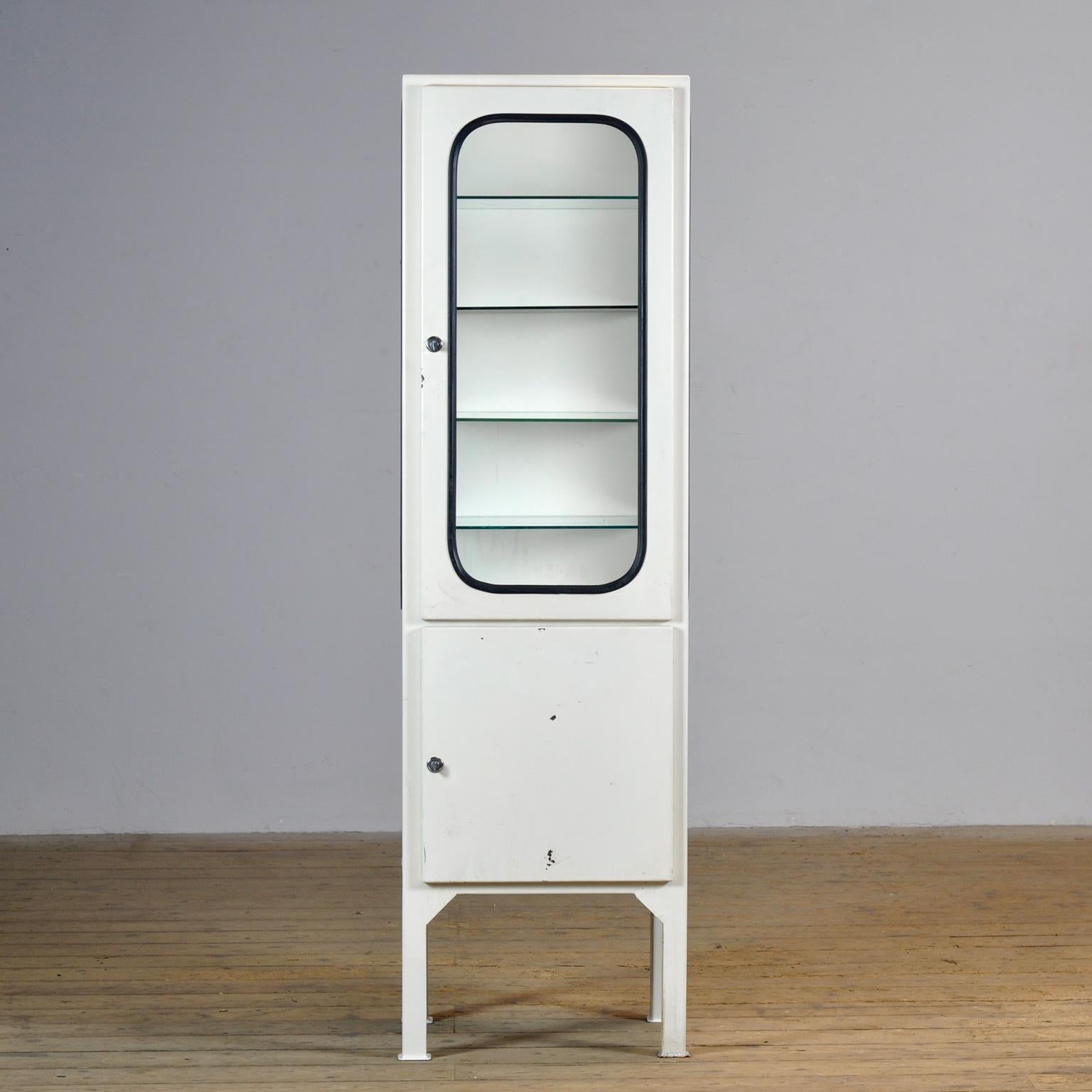 Made of steel and glass that is clamped in the steel by a rubber strip. The cabinet is from the 1970s and was produced in Hungary. Well-functioning locks with keys. The cabinet comes with 4 glass (adjustable) shelves.