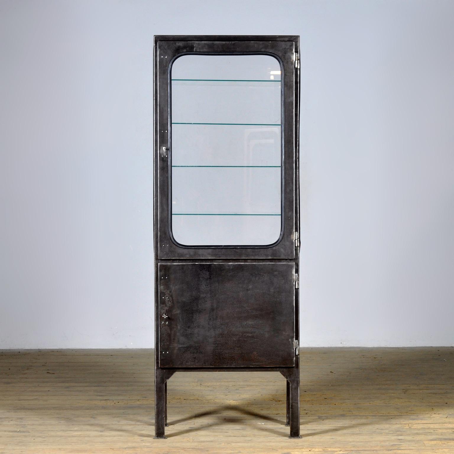 Vintage medicine cabinet from the 1970s, made in Hungary. This cabinet is a real eye-catcher thanks to its industrial design and all-glass walls on all four sides. Made of iron and glass, the glass is firmly clamped to the frame with rubber strips.
