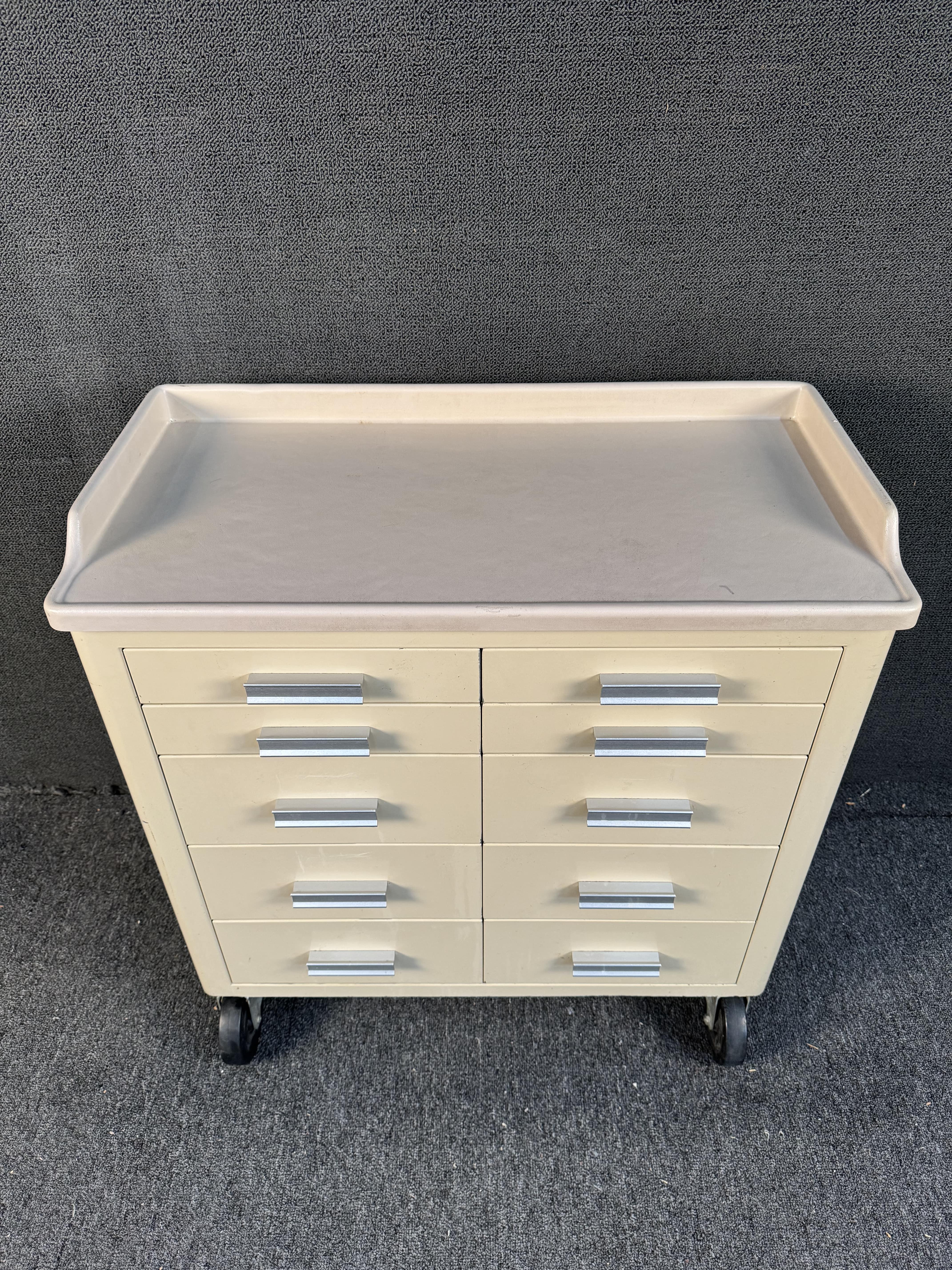 Vintage rolling medical cabinet by United Metal Fabricators. Featuring sleek steel construction, 10 drawers, molded plastic top, and oversized casters. Please confirm location with dealer (NY or NJ)