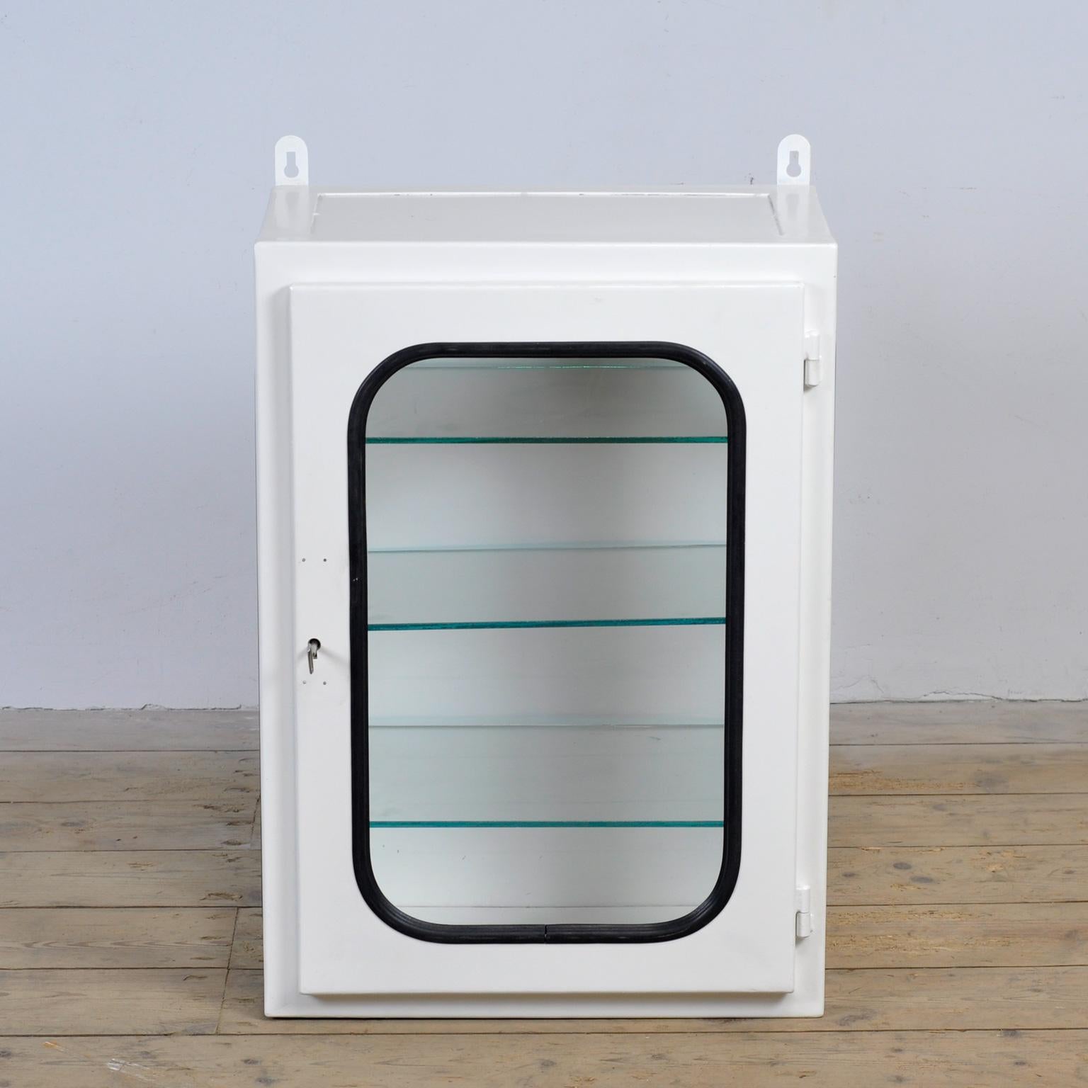 Medicine cabinet (wall unit) from a hospital. Made of iron and glass that is clamped into the steel by a rubber strip. This cabinet comes from the 70s and was produced in Hungary. With 3 adjustable glass shelves.
The cabinet has been repainted and