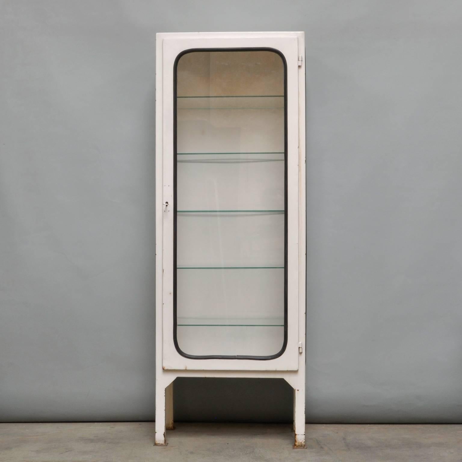 This medicine cabinet, designed in the 1970s and produced circa 1975 in Hungary, is made of steel and glass. The glass panes are held in place by a black rubber strip. The cabinet features five new adjustable glass shelves and a functioning lock.