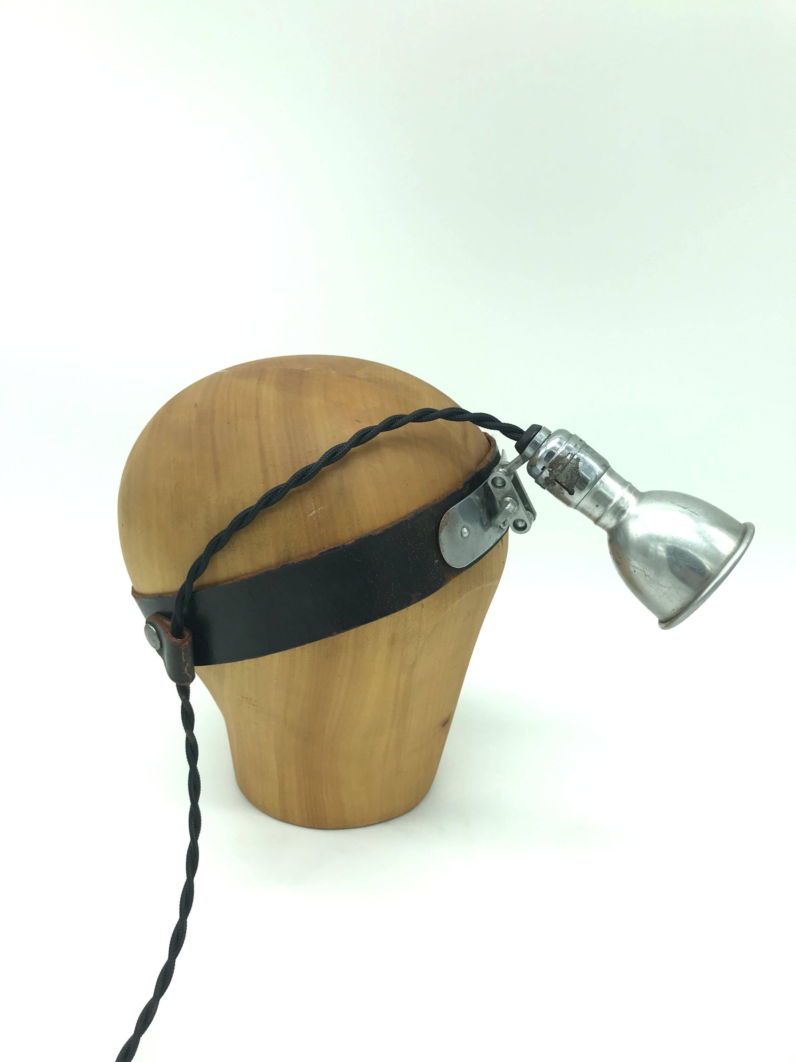 Vintage medical head stand table lamp.
Made from a vintage wooden hat or wig stand and mounted with an antique medical inspection lamp
A cool table lamp like no other
The medical lamp has a small 6 cm aluminum pressed shade and with a carbon