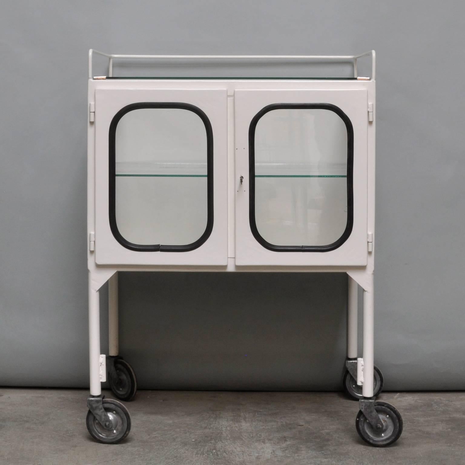 This small medicine trolley was produced in the 1970s in Hungary. It is made from steel and glass. The glass is held by a black rubber strip. The trolley comes with one glass shelve and working lock. The trolley is restored (powder coated in