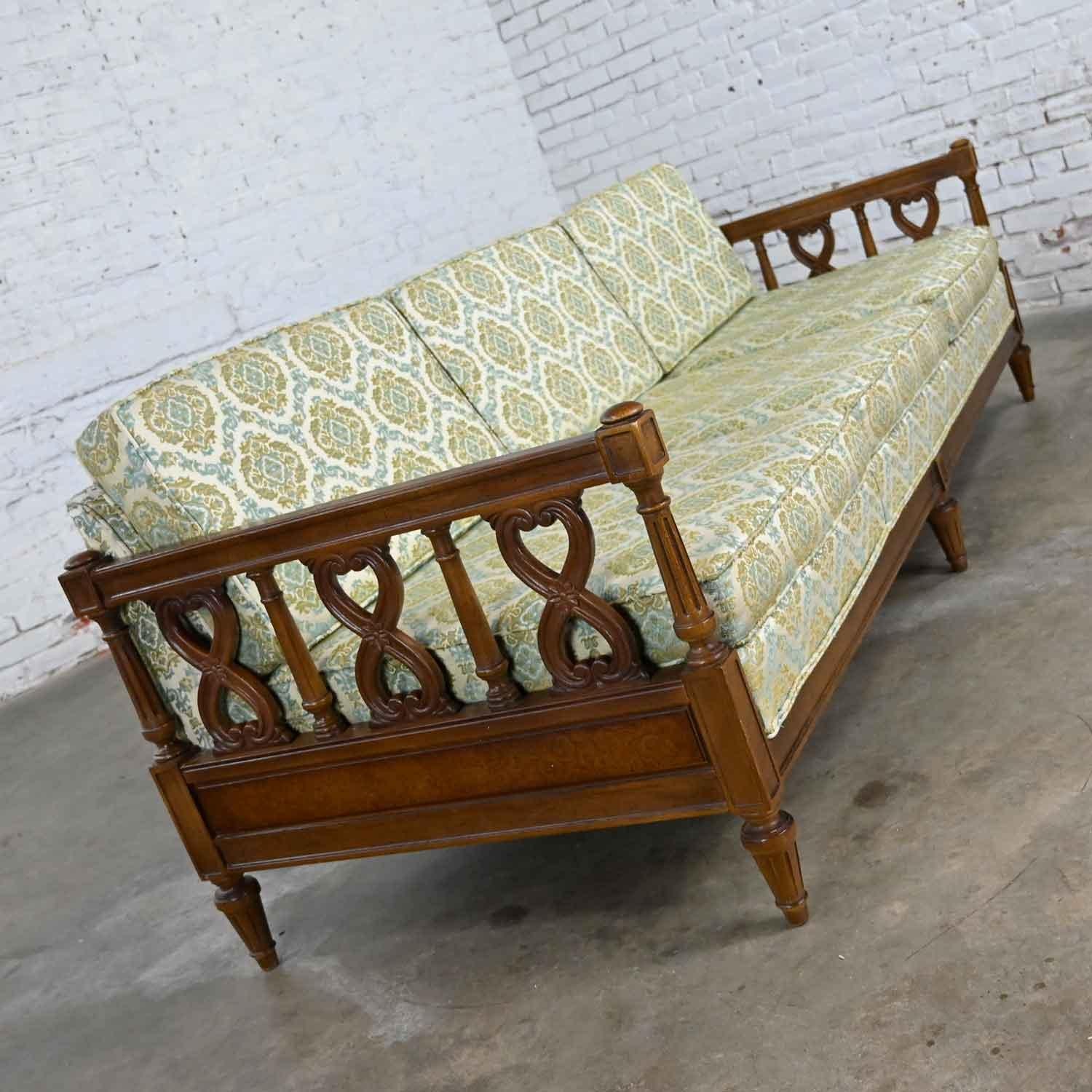 Wonderful vintage Mediterranean or Spanish Revival style sofa with pecan color finish, plastic scroll arm details, burled panels, and loose seat and back cushions in oyster white with blue & green brocade fabric by American of Martinsville.