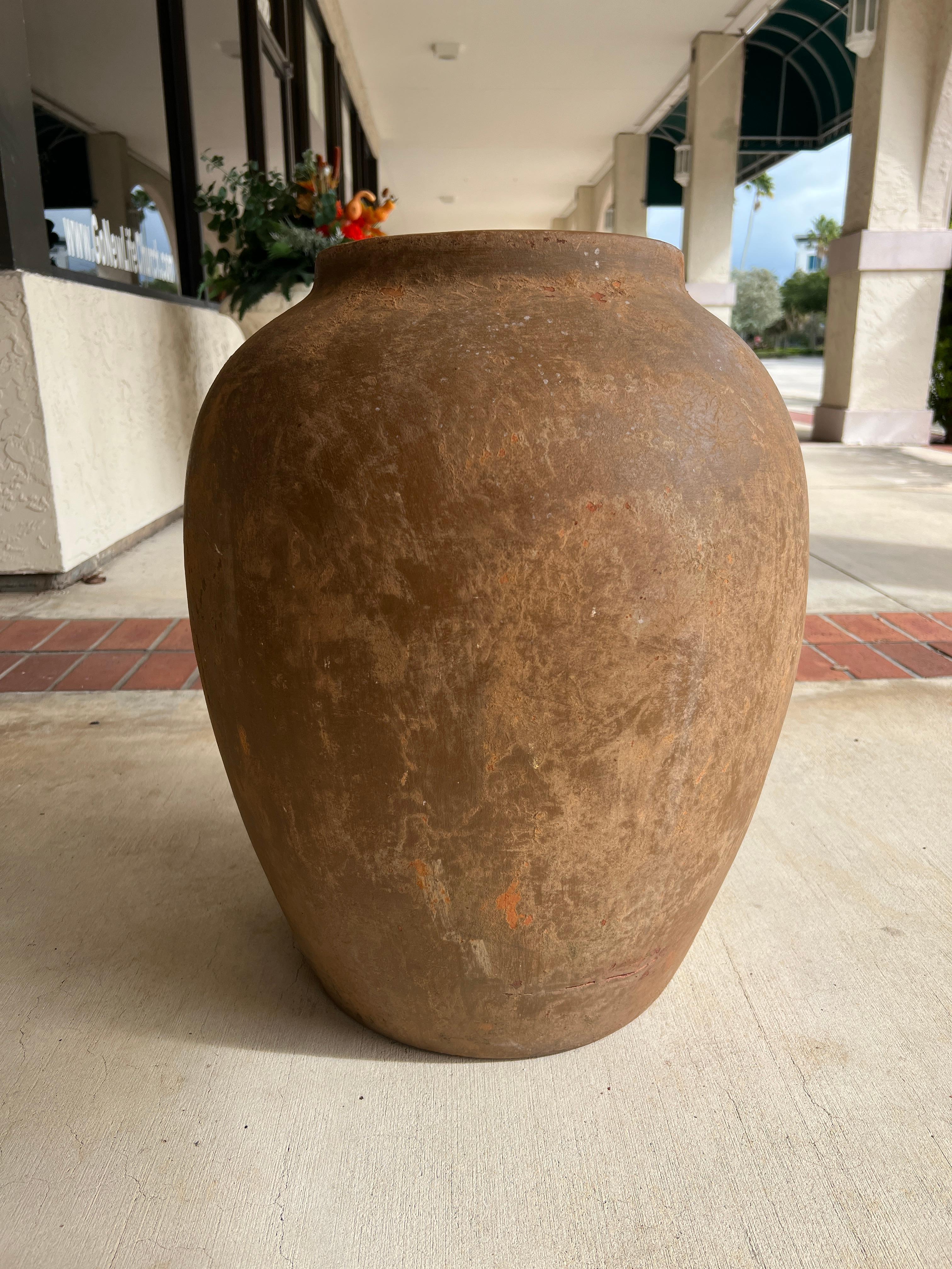 Rustic Mediterranian terracotta olive jar made in Italy. Suitable for inside or outside as a planter or decor. The jar features a drain hole in the bottom.