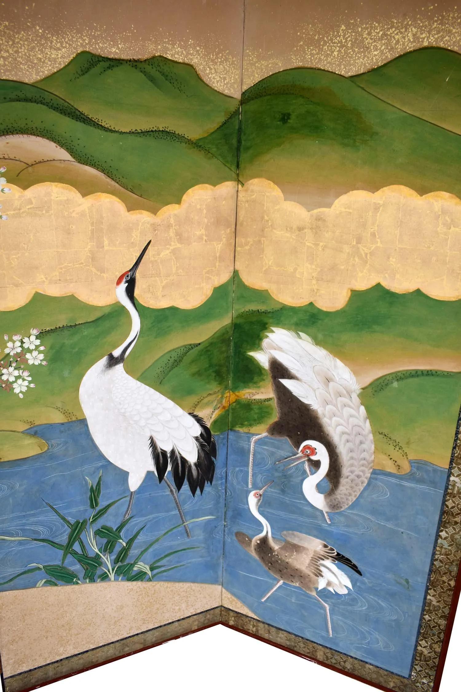 A super chic and beautifully done Vintage Meiji Period Six Panel Japanese Folding Screen Depicting Cranes in Continuous Landscape With Blossoming Foliage and Hills. Possibly signed by artist with black lacquered frame and brass corner accents