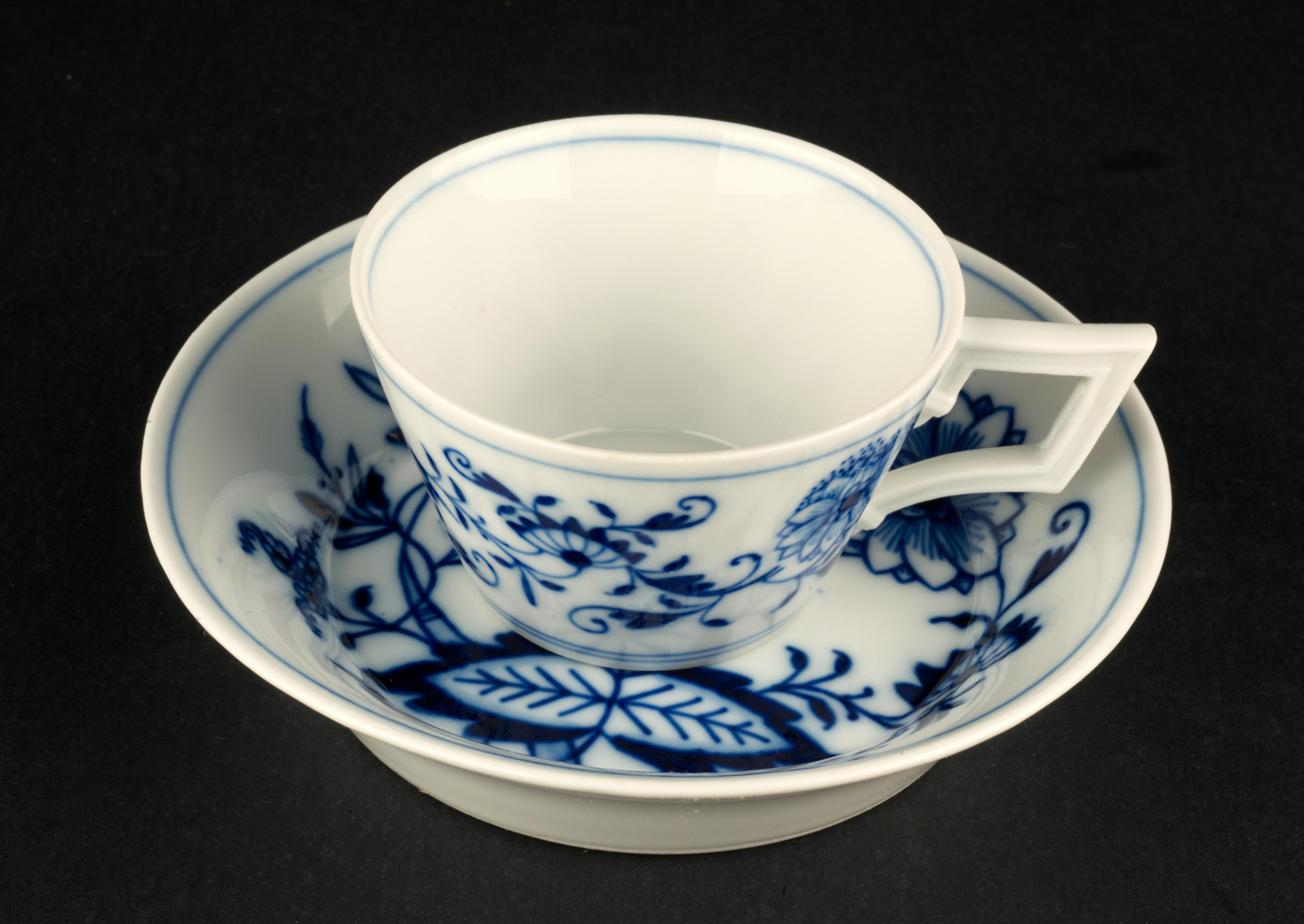  Vintage set of demitasse cup and saucer was made in Germany of semi-transparent bone china. It is decorated with famous Blue Onion pattern; the cup has geometric shape and the angular Berlin shaped handle. The set is marked with crossed swords mark