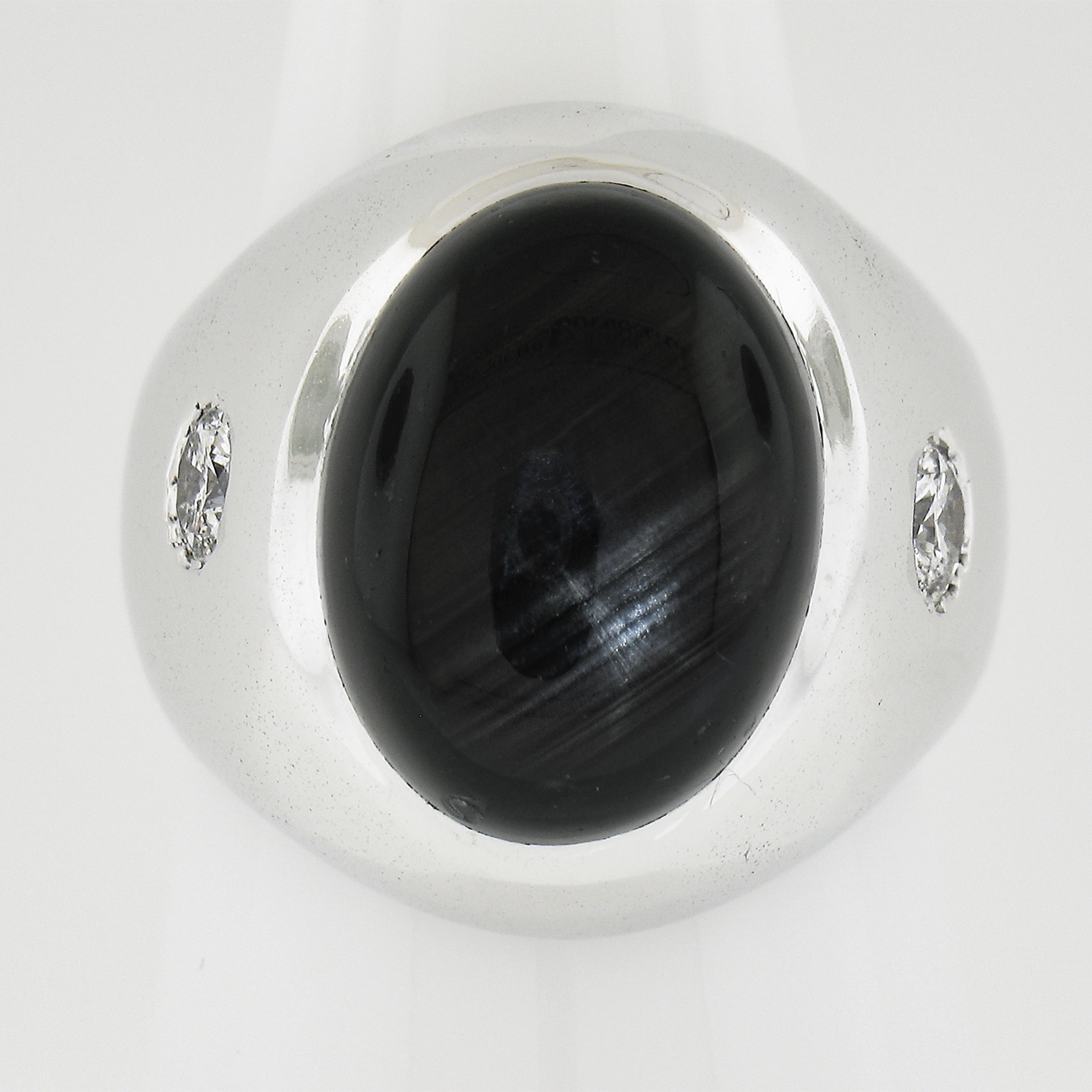 --Stone(s):--
(1) Natural Genuine Star Sapphire - Oval Cabochon Cut - Bezel Set - Black Color - Natural Silks & Striations - 15.69x11.8mm (approx.)
(2) Natural Genuine Diamonds - Round Brilliant Cut - Flush Burnish Set - G/H Color - SI2/I1 Clarity -