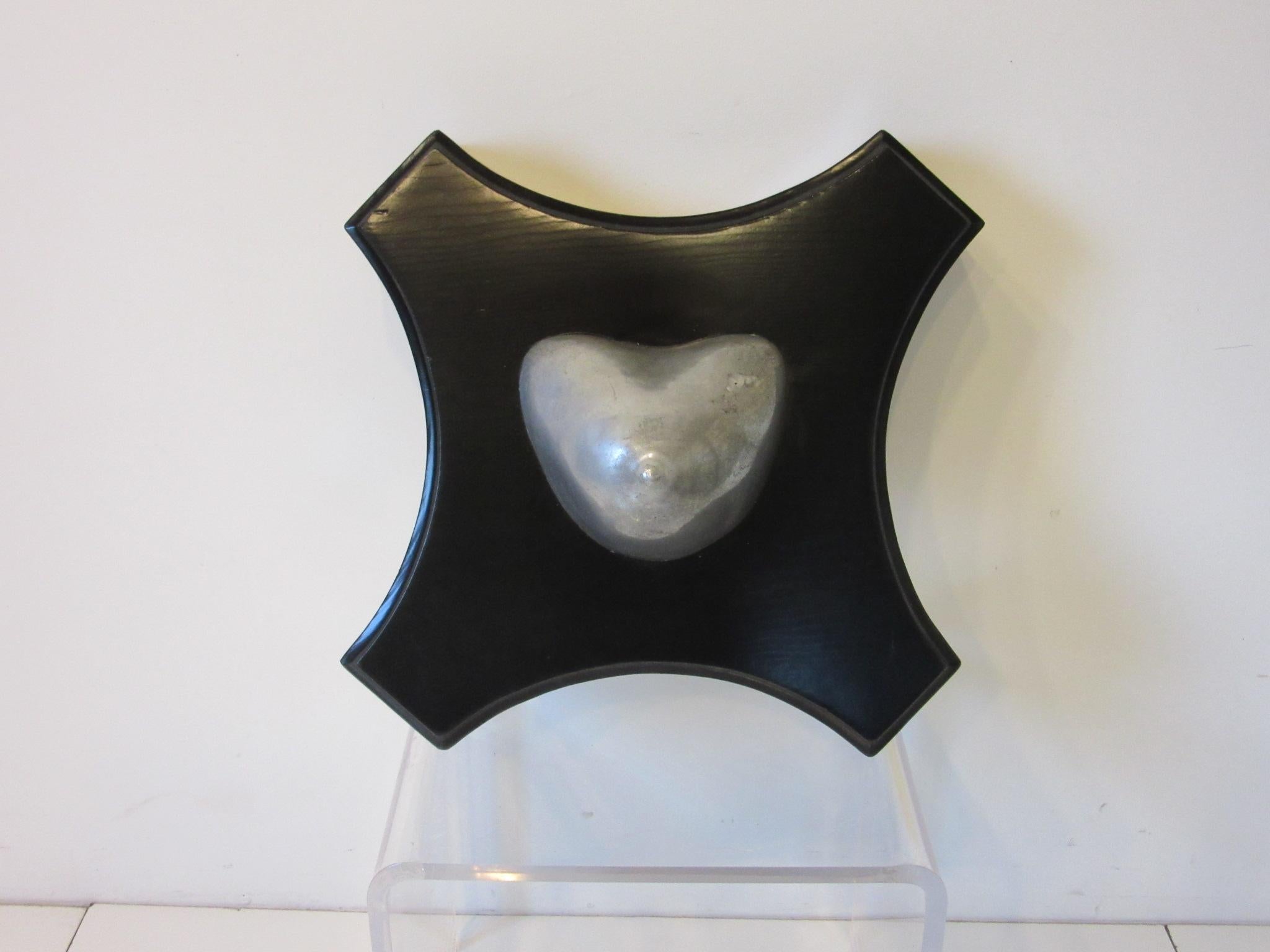 A large vintage plaque / sculpture of a women breast cast in aluminum and mounted to a thickly carved satin black wooden plaque, from a private men's club it hung over the center of the back bar until the mid 1980's. An important historical relic of