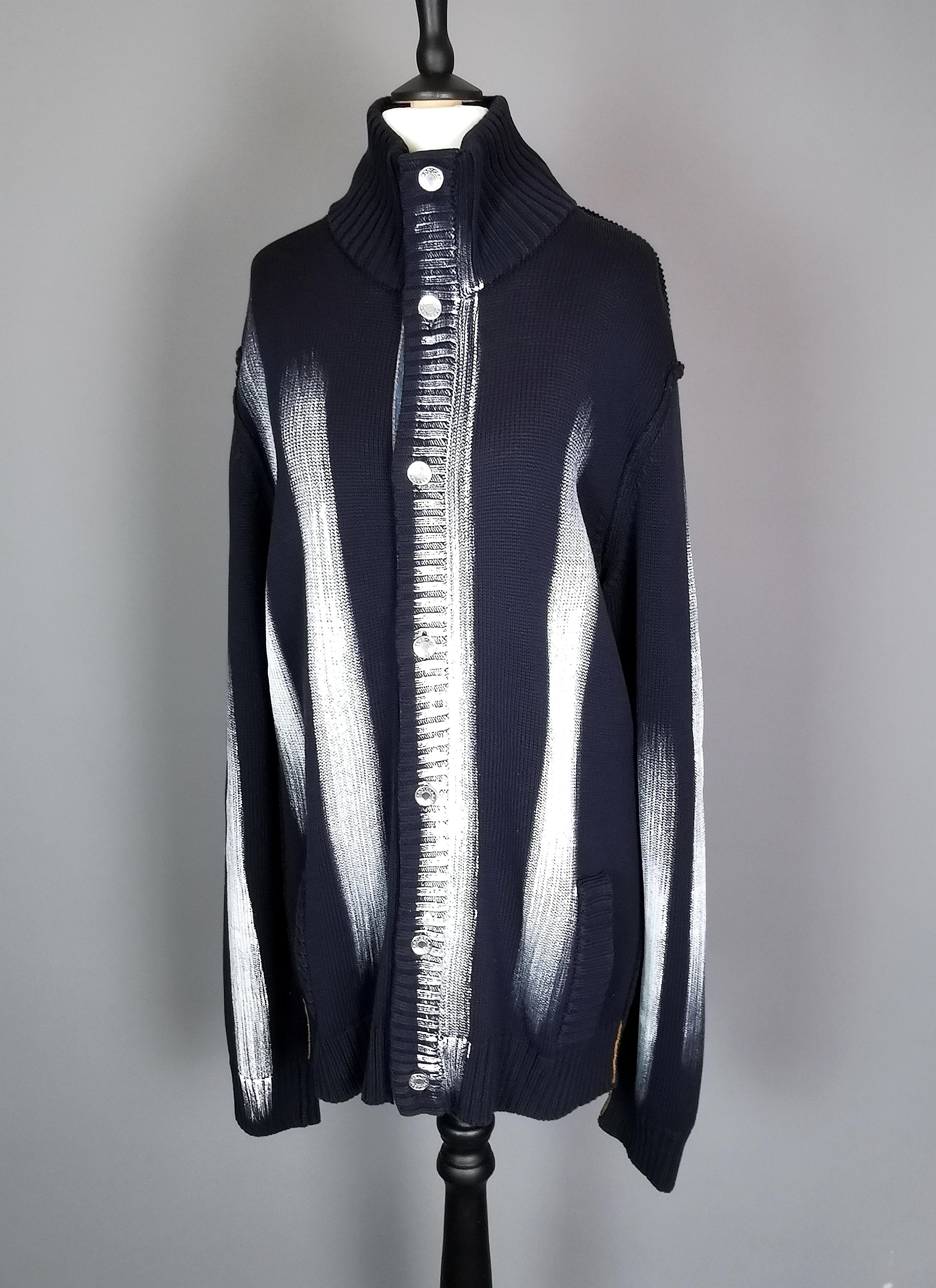 A rare vintage mens Dolce and Gabbana paint stripe cardigan.

Dark navy blue wool mix in a chunky knit with a striking white 'paint' stripe design front and back.

It has a denim trim down the front and silver tone metal buttons with the Dolce and