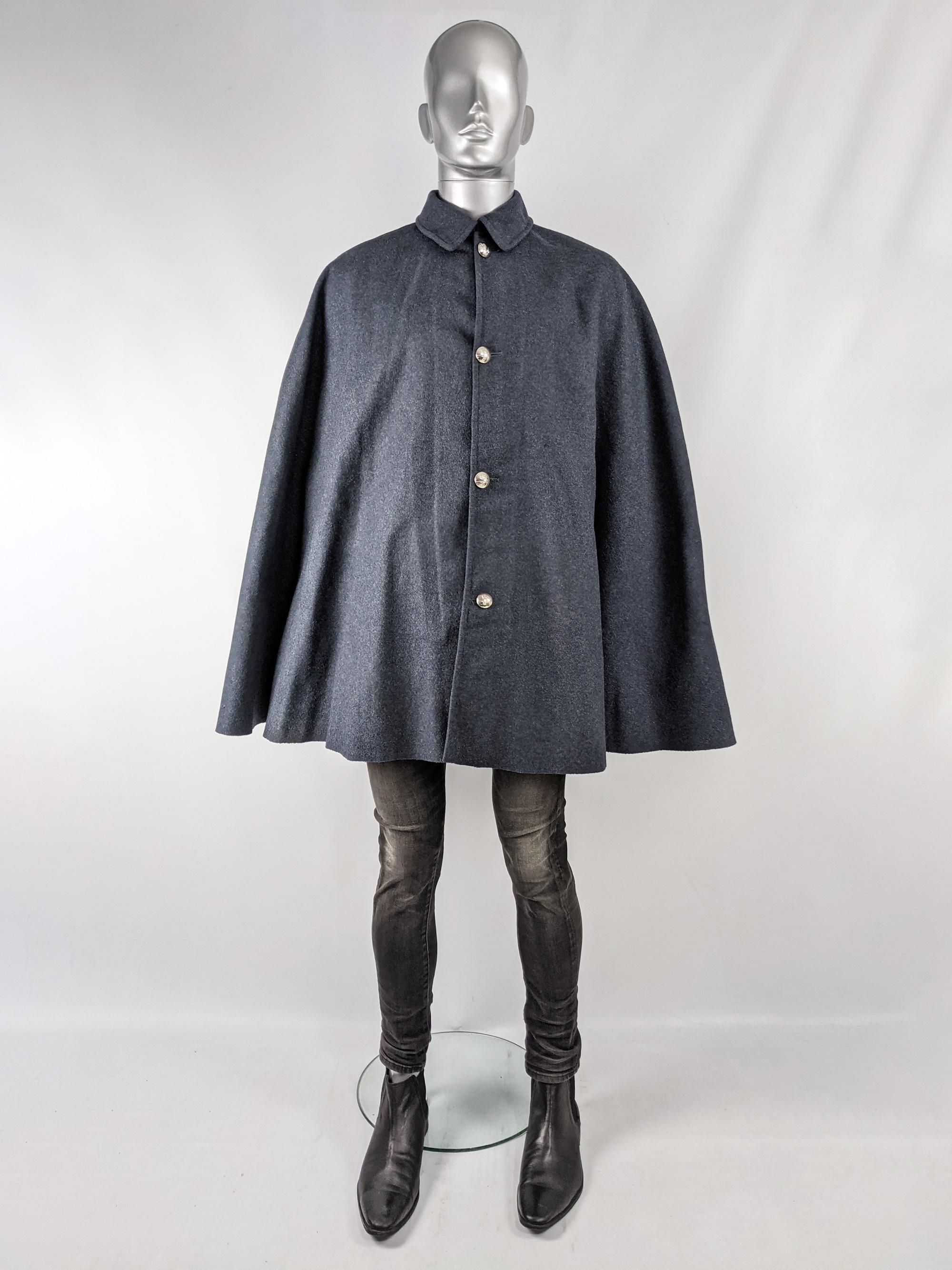 An amazing and rare vintage mens cape from the 60s by British tailors, J Compton Sons & Webb. In a grey wool with the slightest hint of blue. It fastens at the front with silver military style buttons and has an amazing shape that gives a mod /