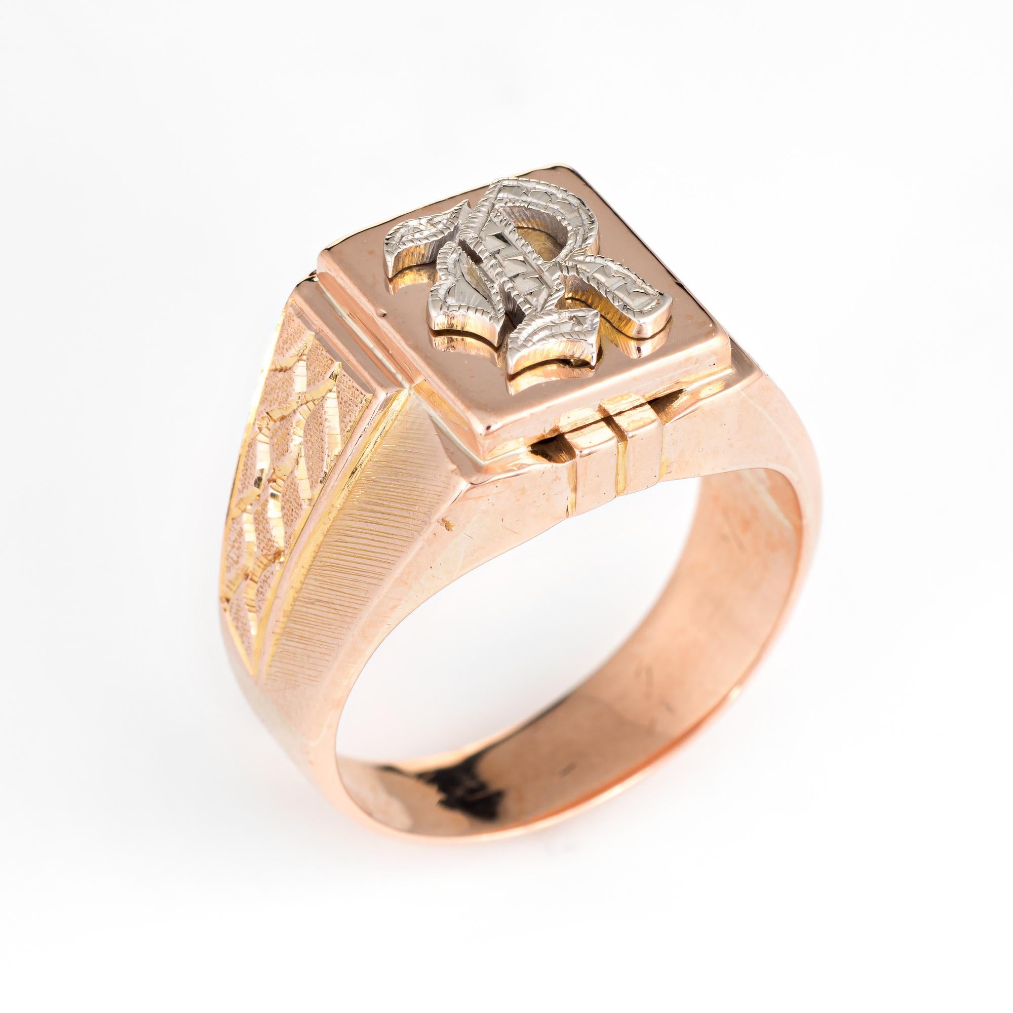 Vintage men's letter 'R' signet ring (circa 1960s to 1970s), crafted in 10 karat rose gold. 

The letter 'R' is rendered in old English font (white gold). The side shoulders feature a textured pebble style design in opposing form. With a medium rise