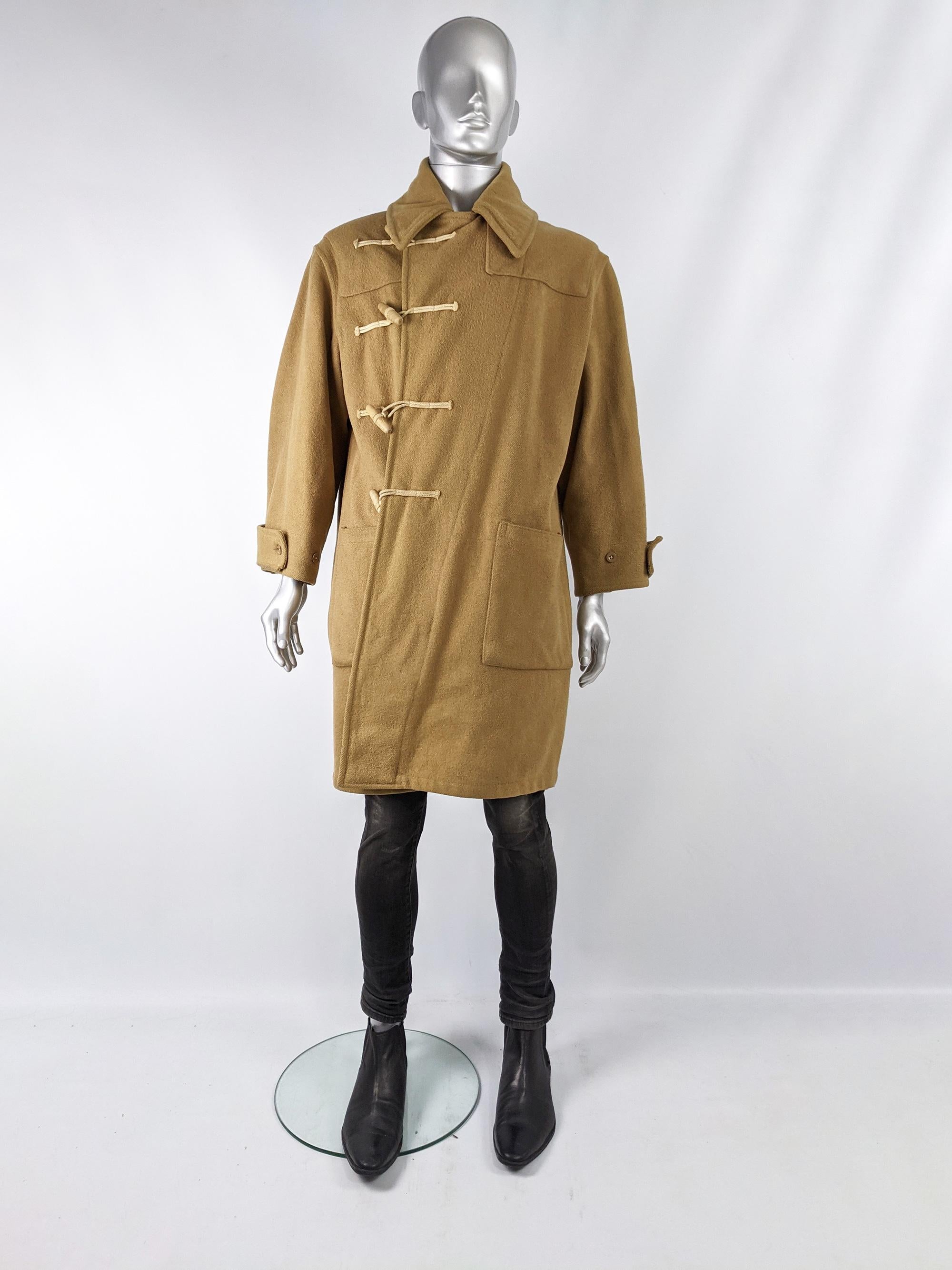 An excellent vintage mens midcentury naval / workwear duffle coat dating from between the 40s and 60s. In a camel coloured wool with asymmetric duffel toggle fastenings which means the front panel wraps the full way across the chest, creating two