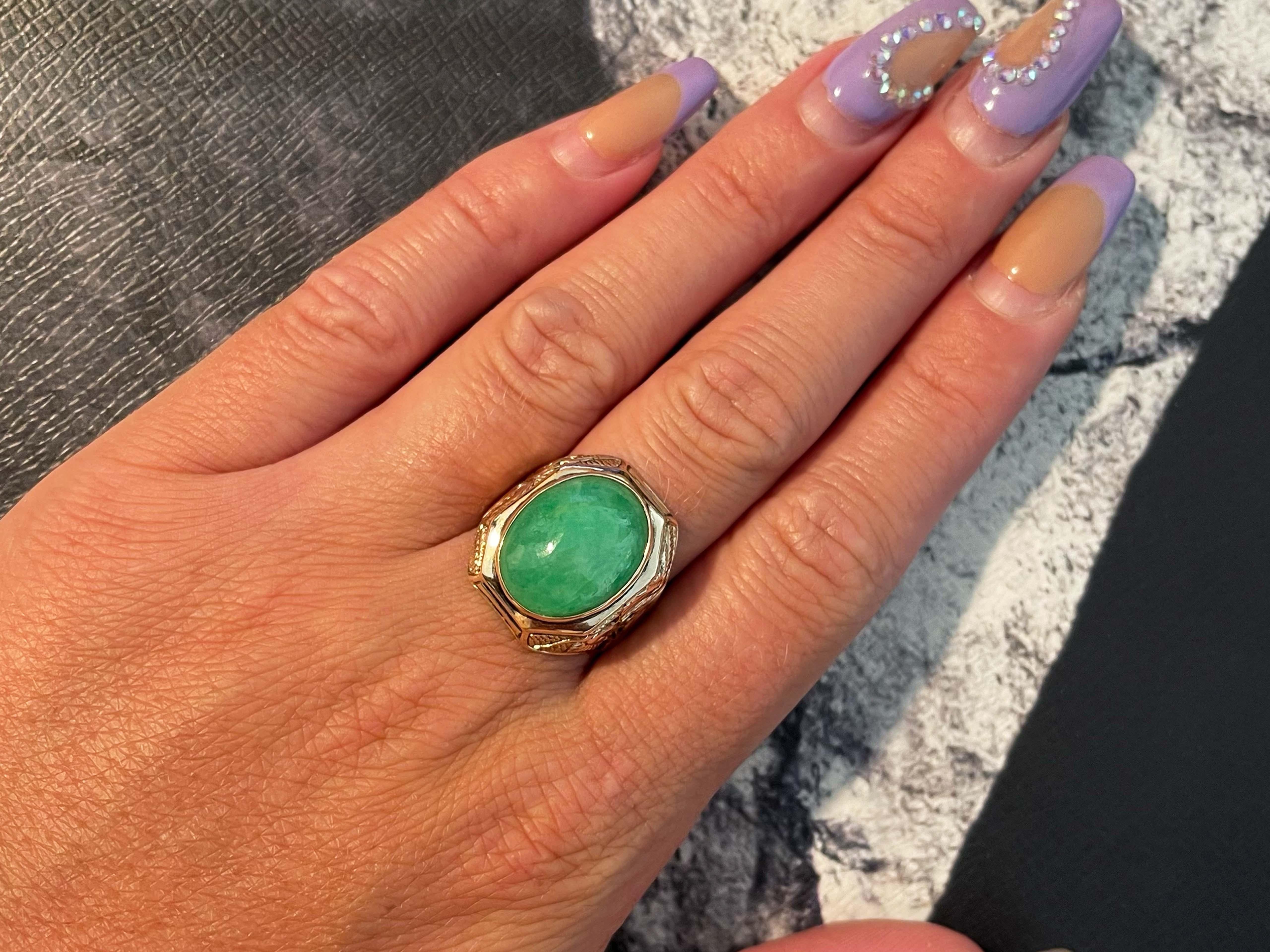 Magnificent vintage oval cabochon green jadeite jade ring in 14k rose gold. The beautiful mottled green Jade is bezel set and measures approximately 16.29 mm x 13.03 mm x 7.28 mm. The ring has a tapered shank with a cut out Dragon design on the
