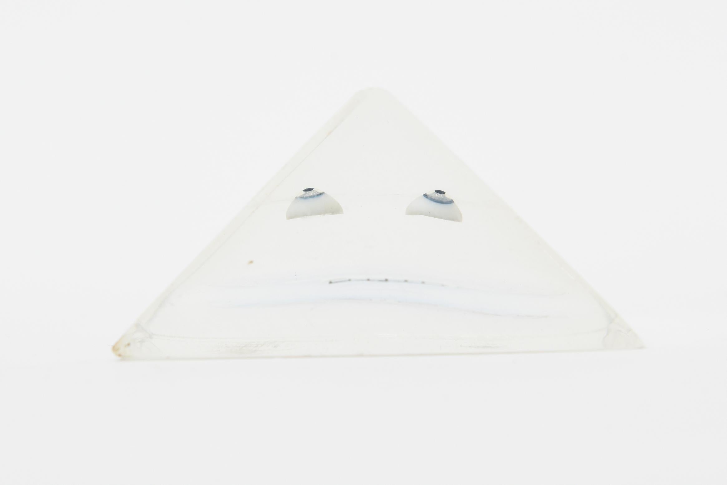 Questa scultura vintage in lucite op art e acrilico incastonato a forma di piccolo triangolo è opera di Merle Edelman, risalente agli anni 70. Si tratta di un volto e di occhi con linee architettoniche a griglia che sono 3 D e geometriche.  È post