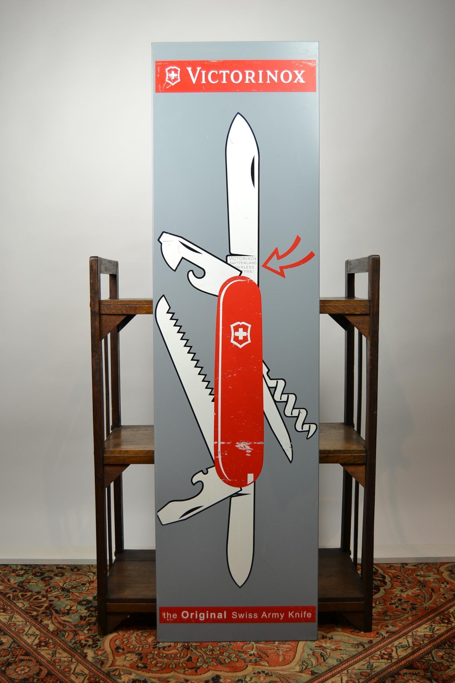 Vintage metal publicity wall sign for Victorinox - known for its Swiss Army knives.

The company was founded in 1884. Since 1891, the company has delivered knives to the Swiss army. Their emblem / logo is a cross in a shield and has been used by