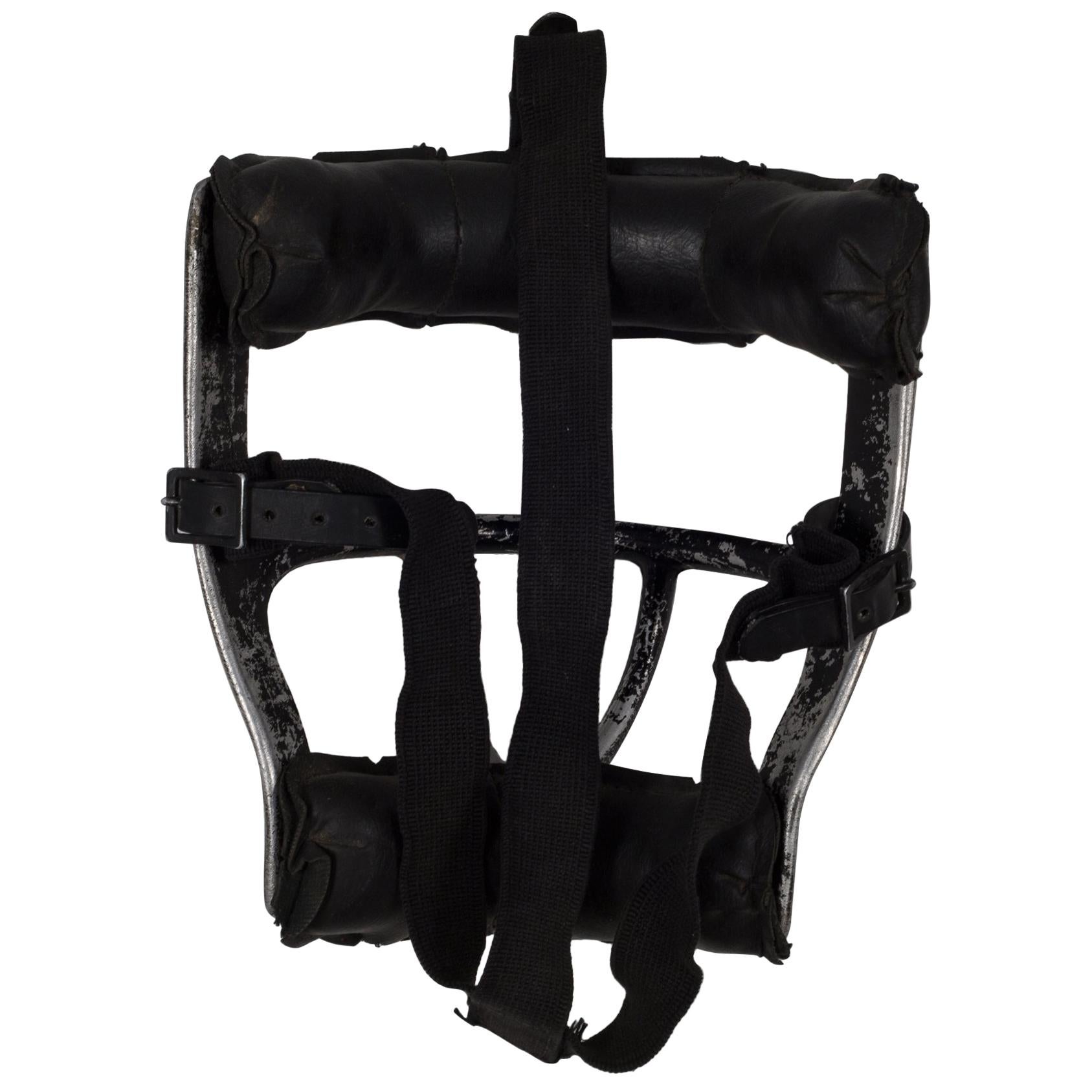 About

This is an original vintage catcher's mask. The main body is aluminum with thick, black leather padding. The padding is held onto the body of the mask by leather straps with brass snaps. The piece has retained most of it's original finish