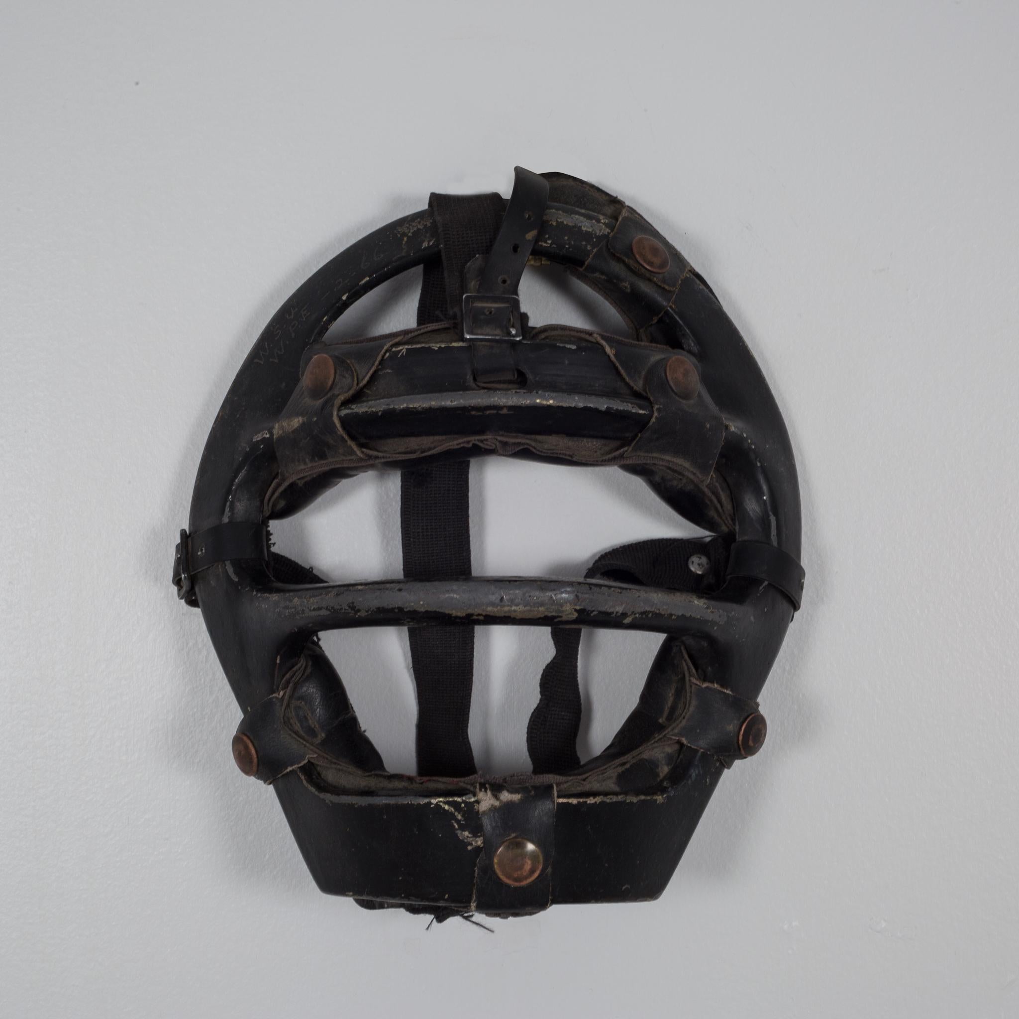 About

This is an original vintage catcher's mask. The main body is aluminum with thick, black leather padding. The padding is held onto the body of the mask by leather straps with brass snaps. There are initials and an date scratched on the upper