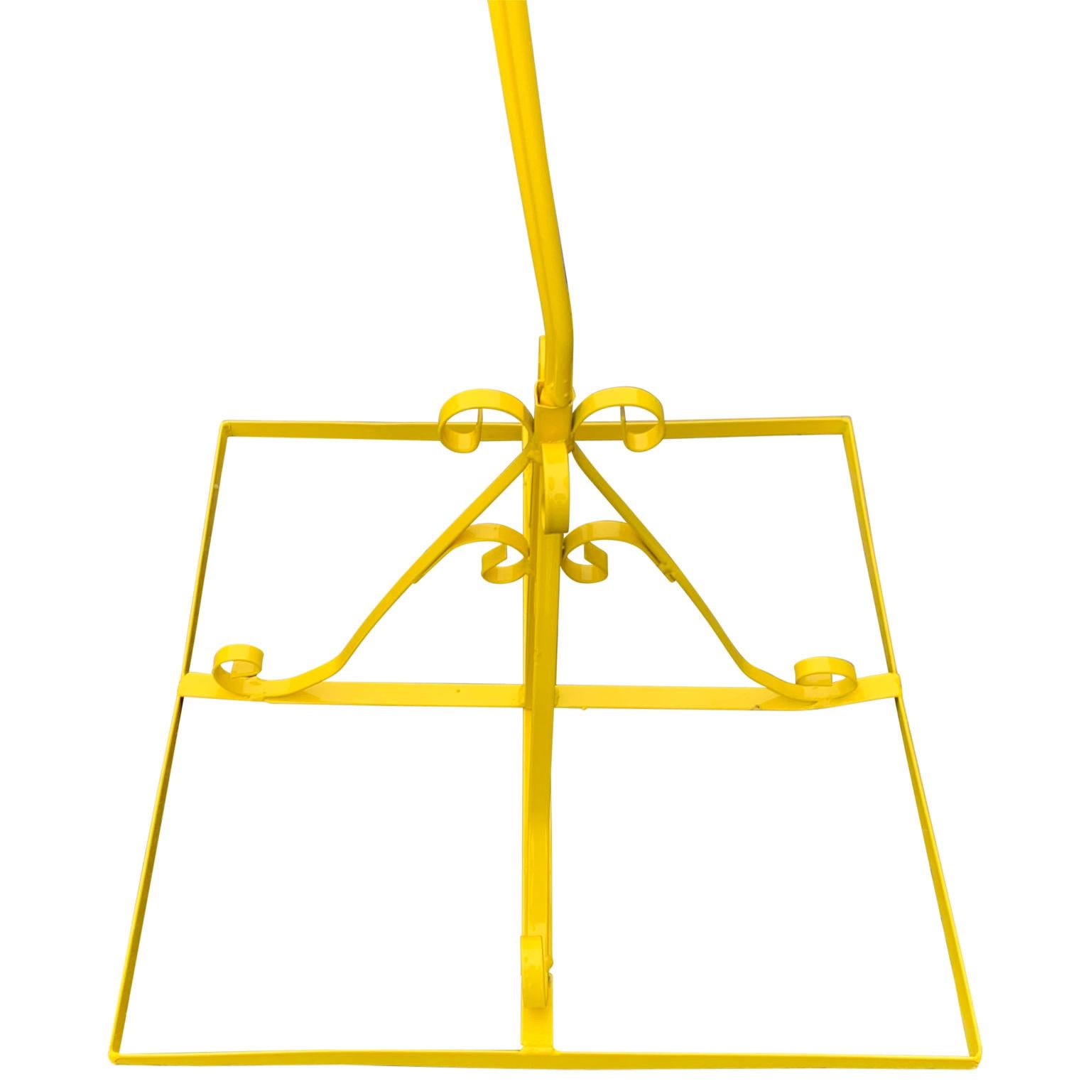 Vintage metal birdcage on stand, newly powder-coated in bright sunshine yellow.