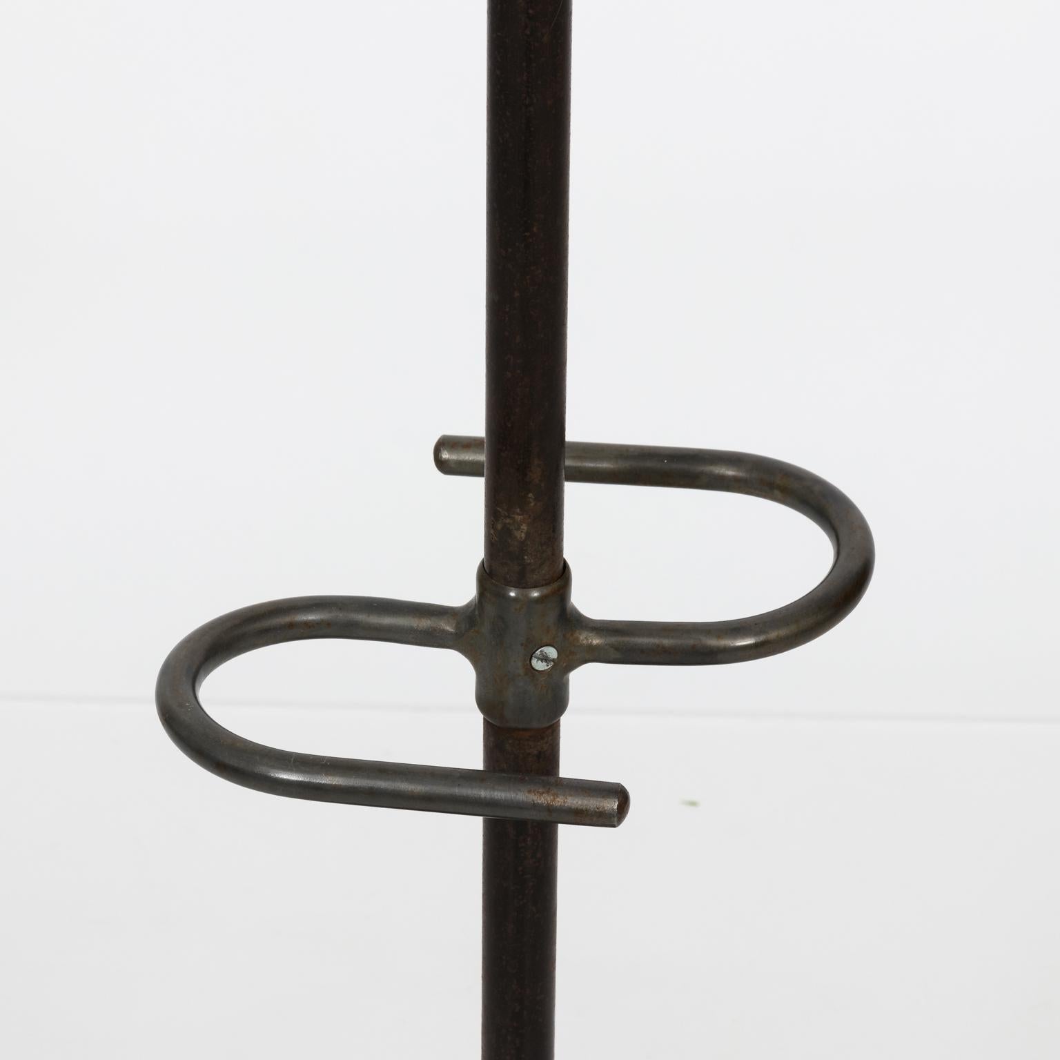 Vintage metal coat rack with six hooks and bottom umbrella stand, circa 1950s.