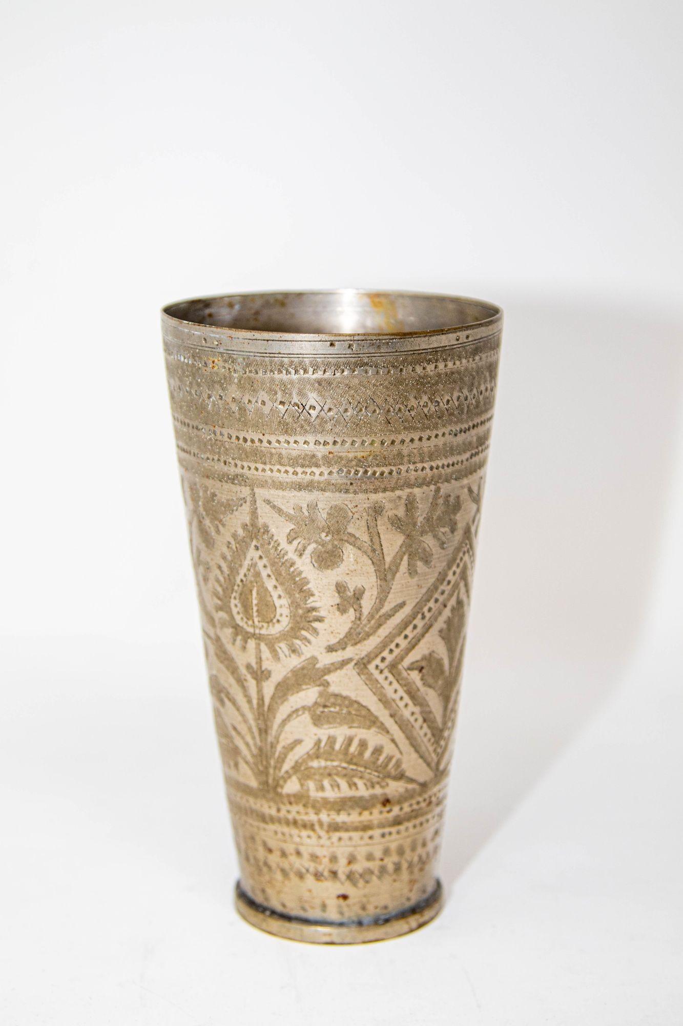 Antico bicchiere inciso in metallo argentato martellato a mano splendidamente cesellato e decorato con motivi geometrici e botanici.
Un esemplare unico di antica tazza islamica in metallo per bere lassi in stile Mughal, proveniente dall'India e