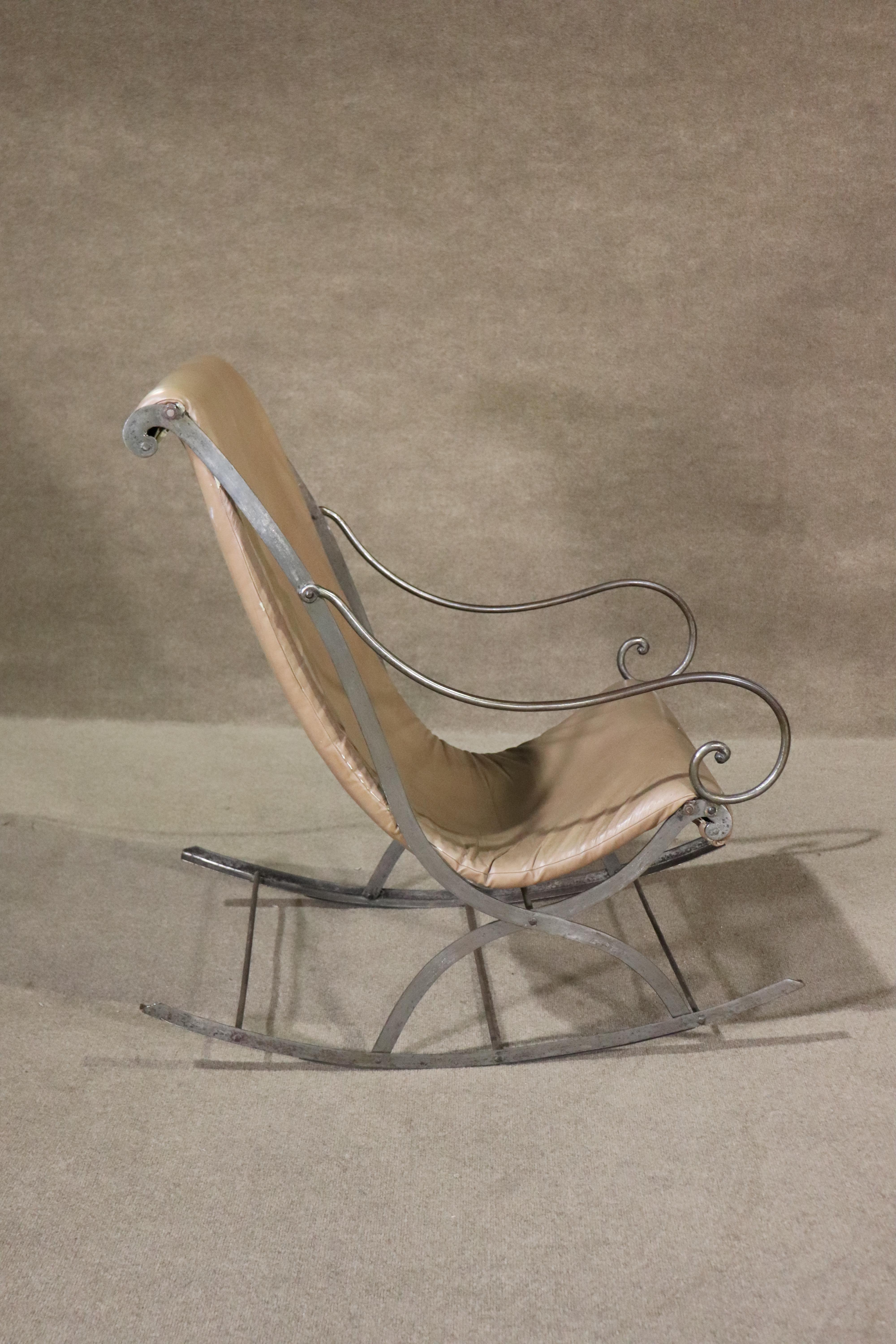 This mid-century rocking chair is built with a strong metal frame with a curving vinyl seat. 
Please confirm location NY or NJ